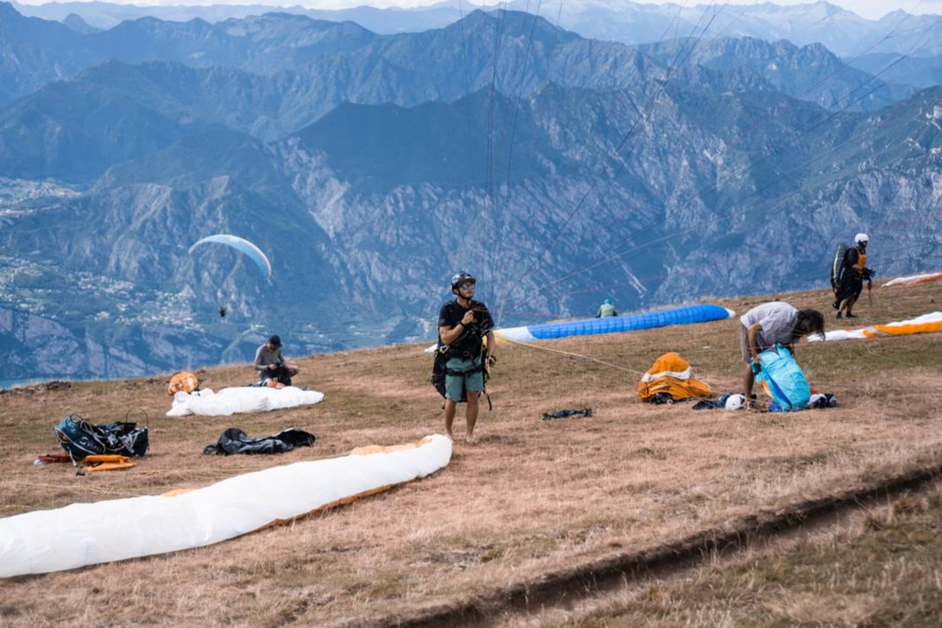 Paragliders launching from Billing's ridge with the Kangra valley spread out below