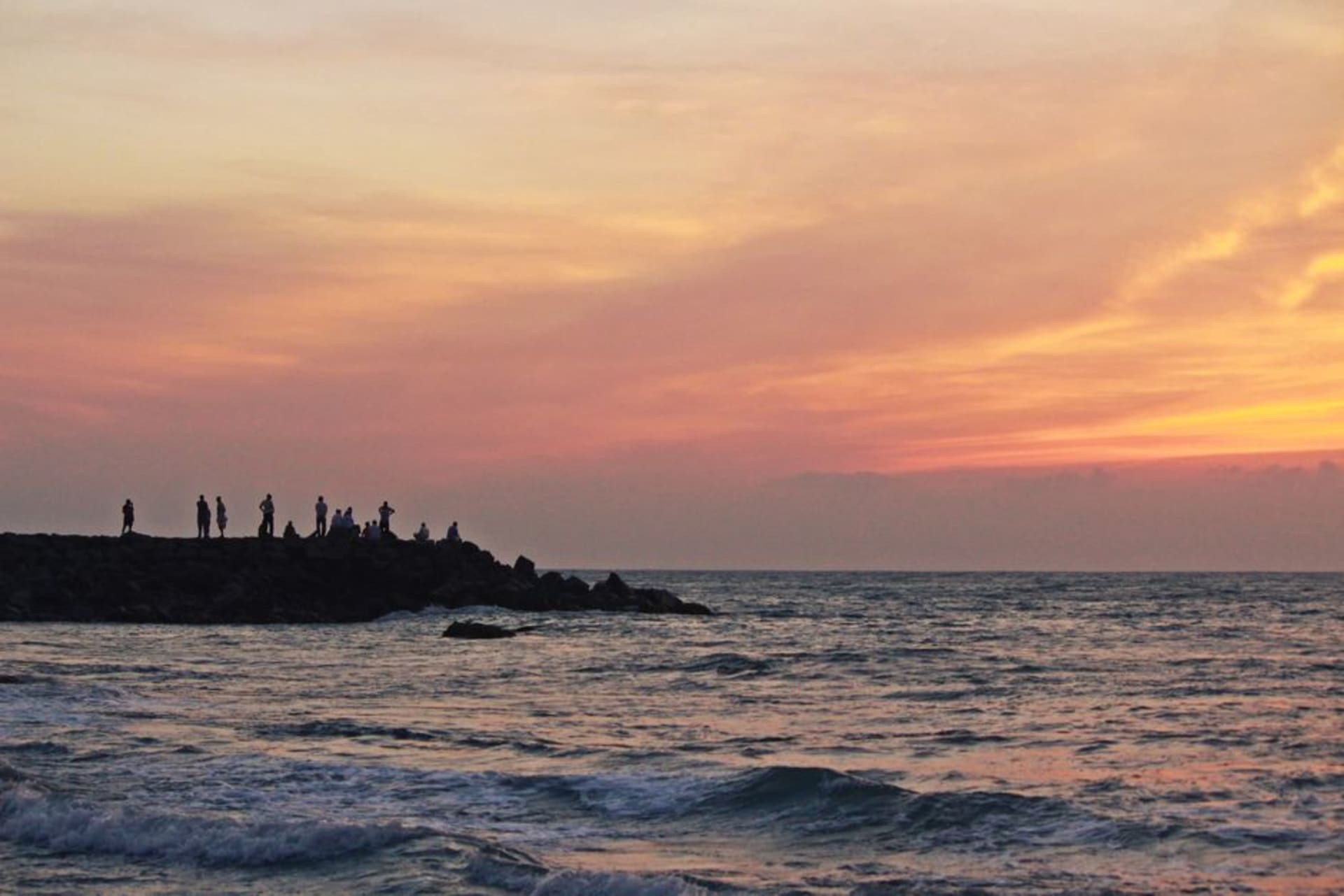 Waves from three converging seas crashing against the rocks at Kanyakumari with the Vivekananda Rock Memorial offshore