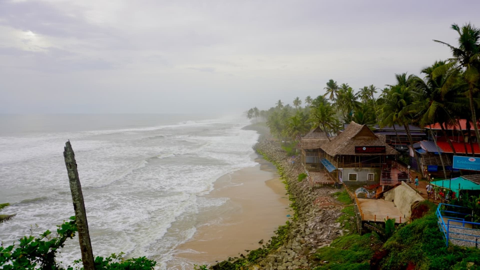 Kovalam's Lighthouse Beach curving along the Arabian Sea with the red-and-white lighthouse above