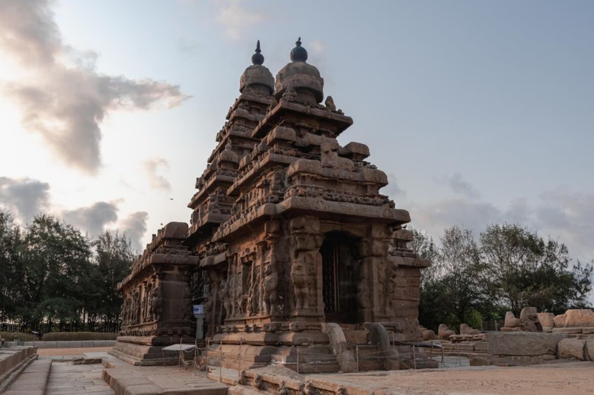The stone Shore Temple of Mahabalipuram silhouetted against the Bay of Bengal at sunrise