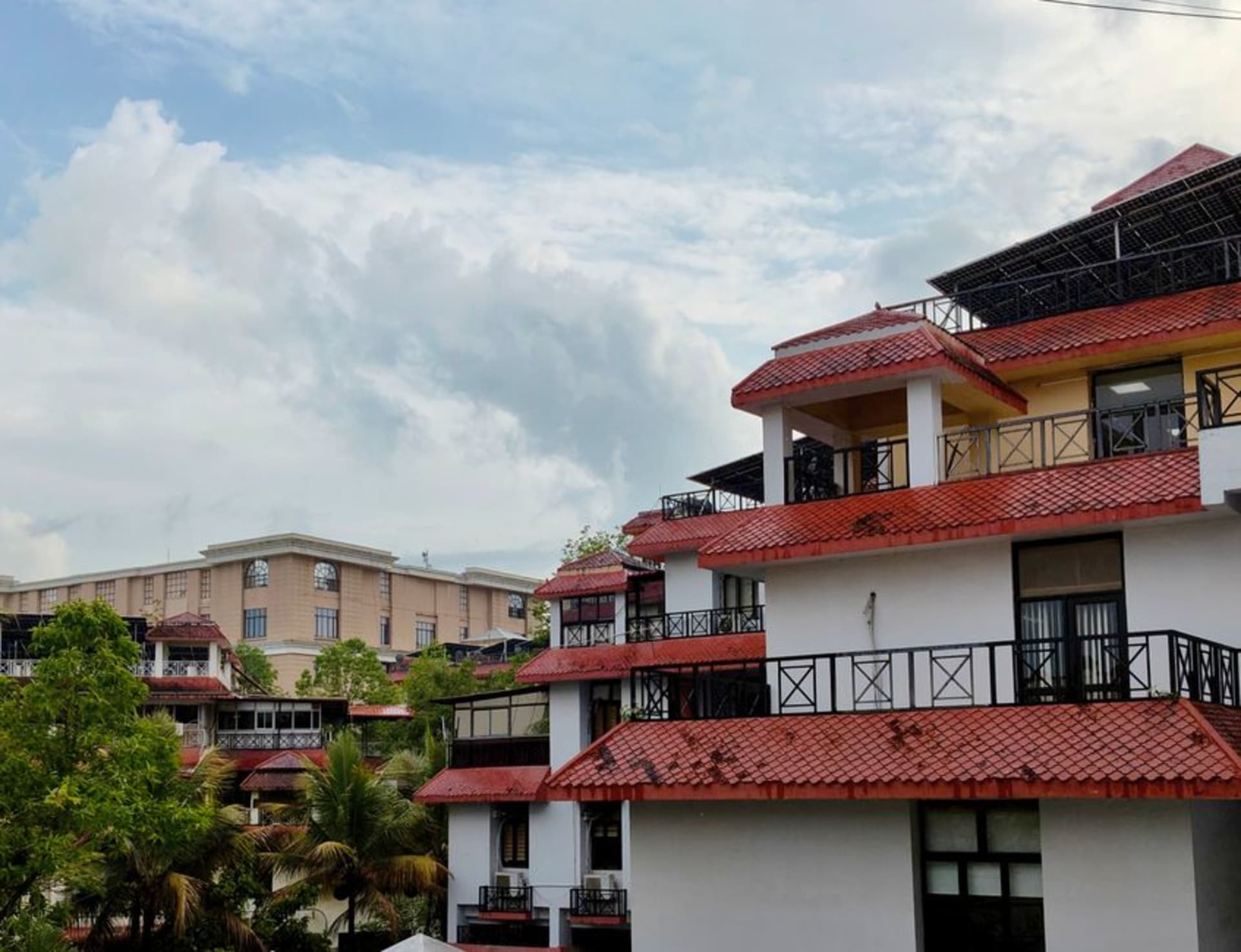 Red-tiled roofs of old Mangalore houses stretching toward the Arabian Sea under a humid coastal sky