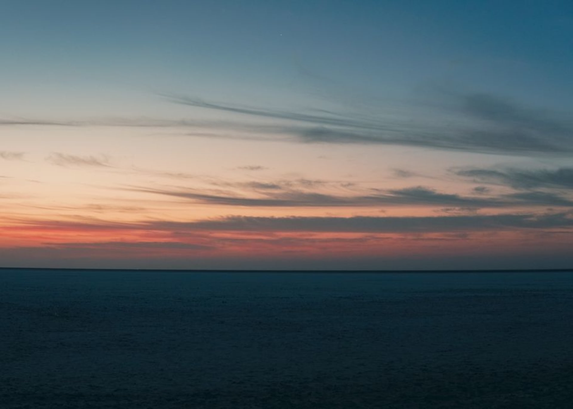 Endless white salt flat stretching to the horizon under a full moon at the Rann of Kutch