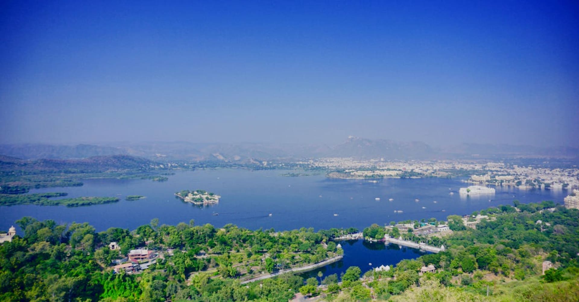 White palace reflected in the calm waters of Lake Pichola at twilight