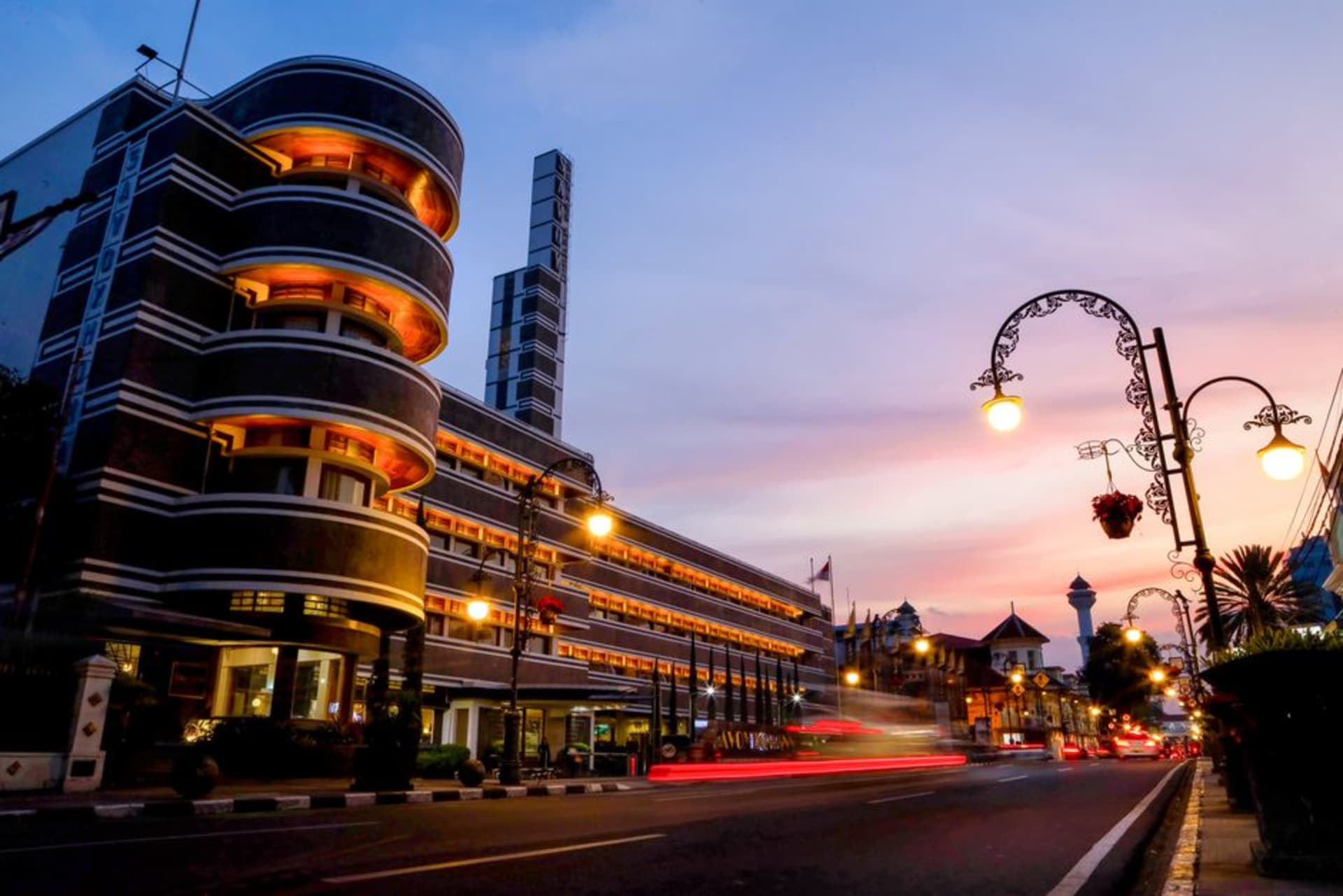 Art deco architecture along a Bandung street with mountains in the distance