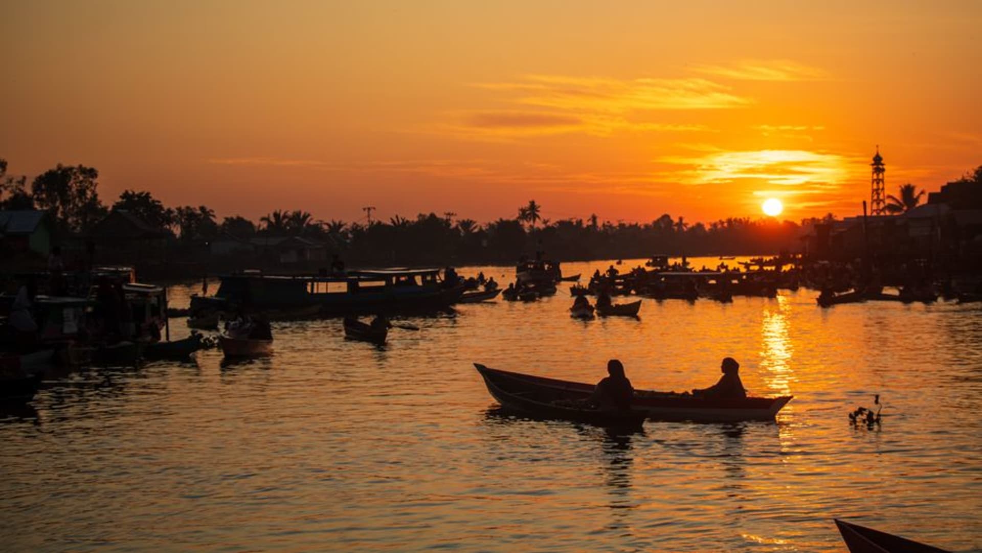 Colorful wooden boats gathered at the floating market on Banjarmasin's rivers at dawn