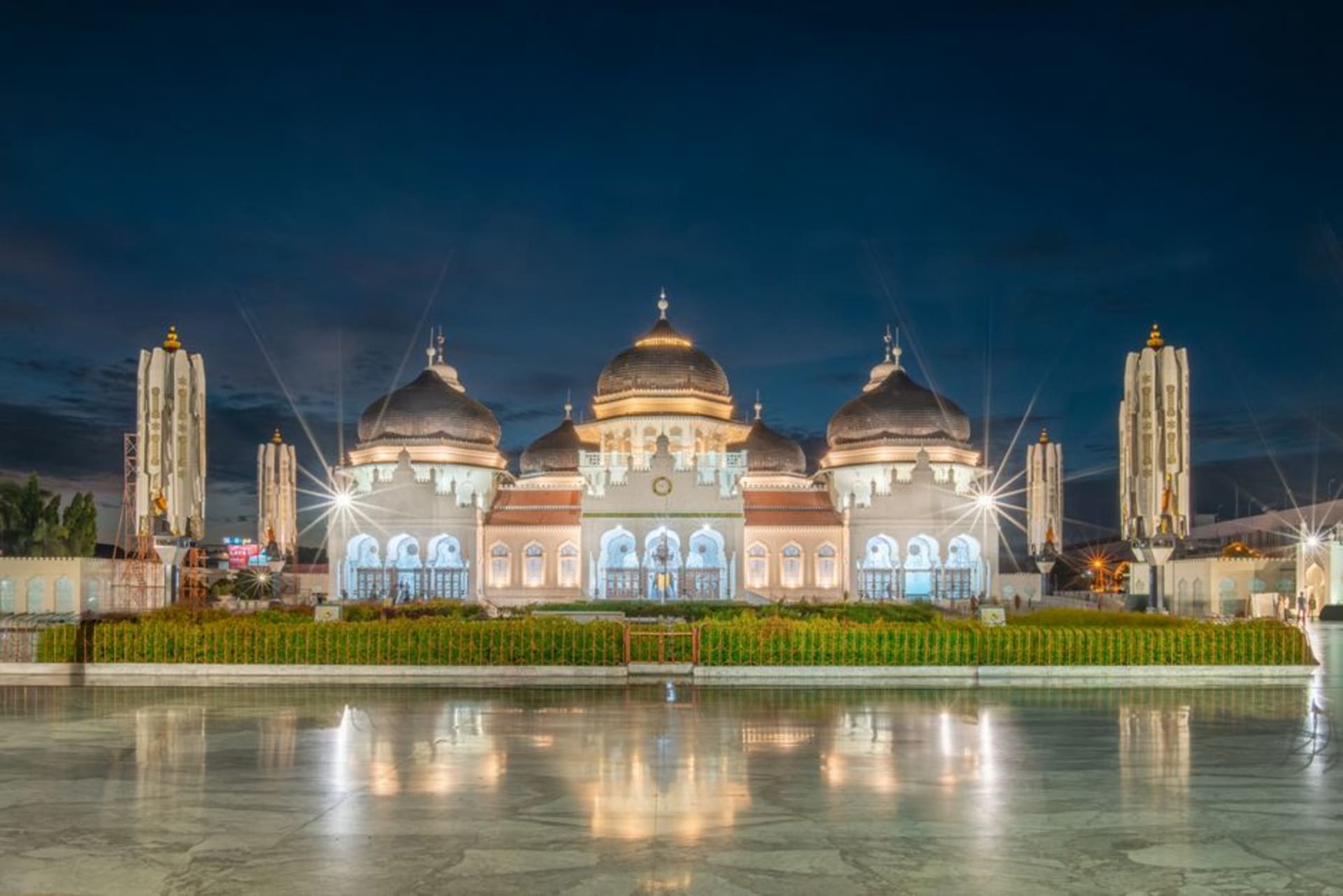 The black domes and white minarets of Baiturrahman Grand Mosque in Banda Aceh at dusk