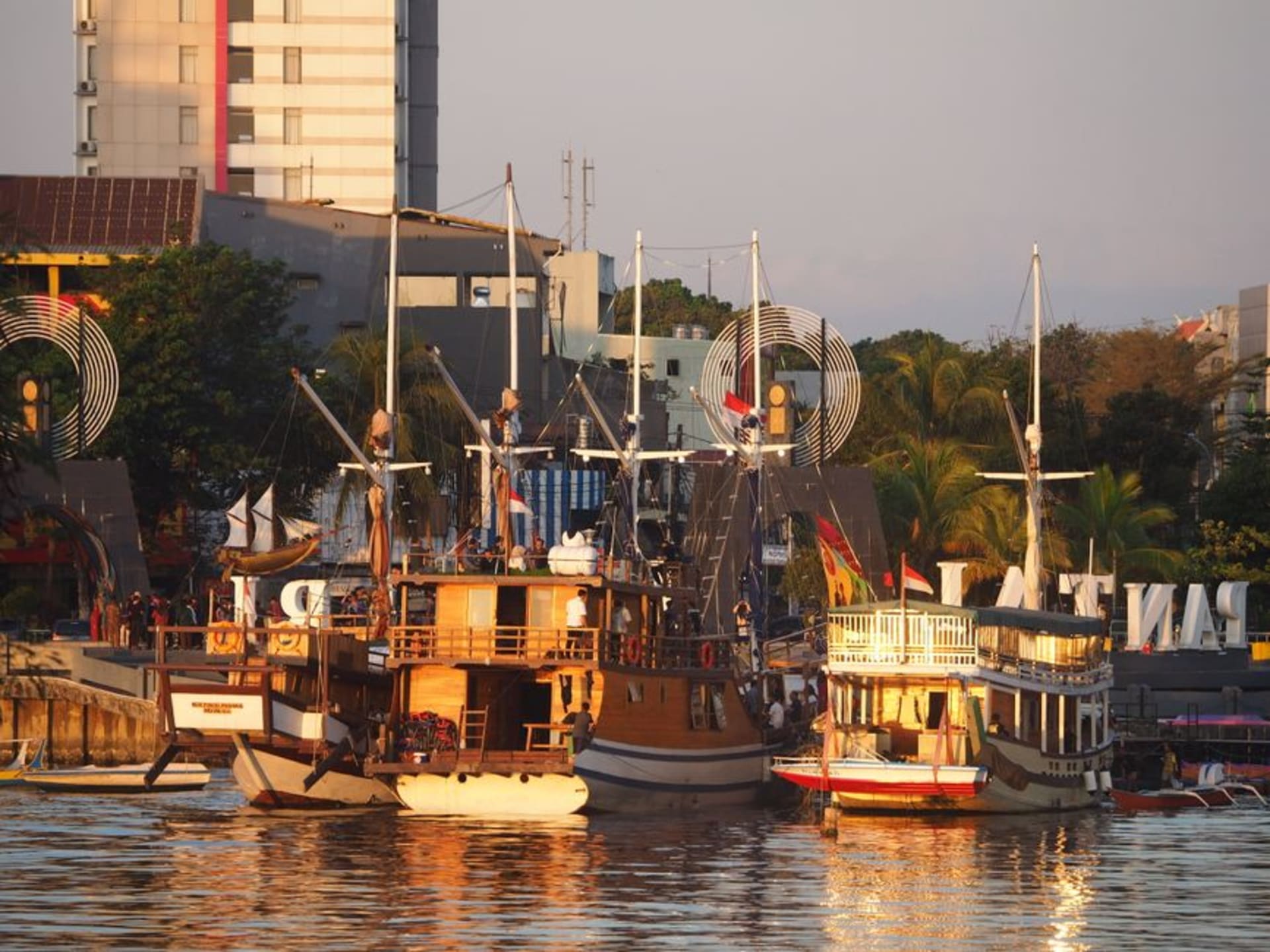 Traditional Bugis pinisi schooners moored at Paotere harbor in Makassar at golden hour