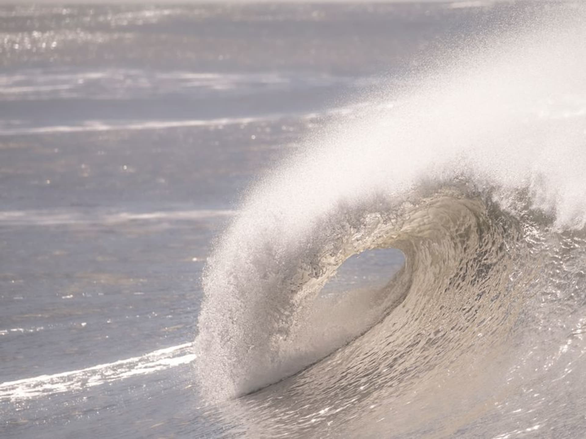 A perfect barreling wave breaking over a reef off the Mentawai Islands at sunset