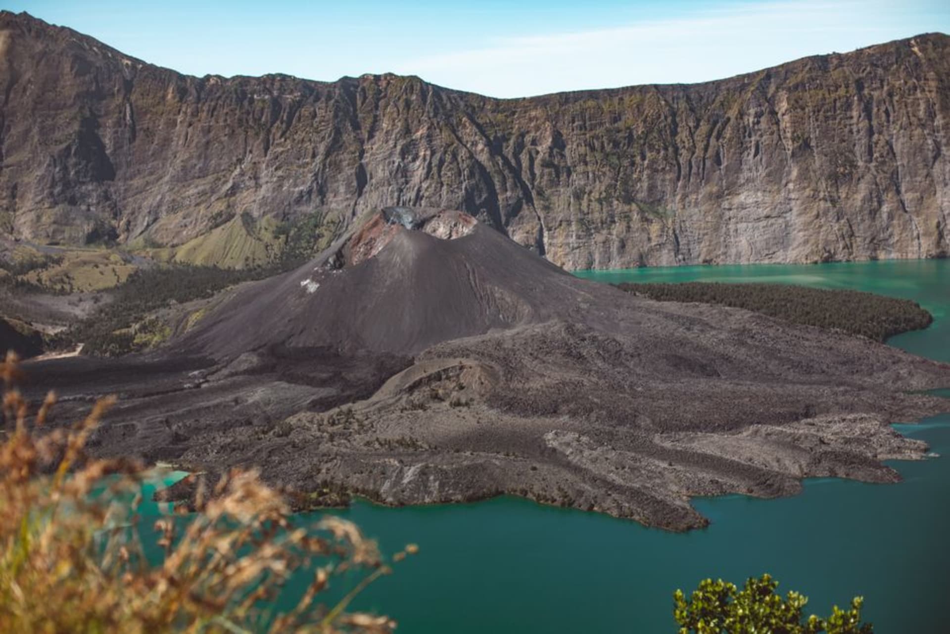 Mount Rinjani's volcanic peak rising above clouds with the crater lake below