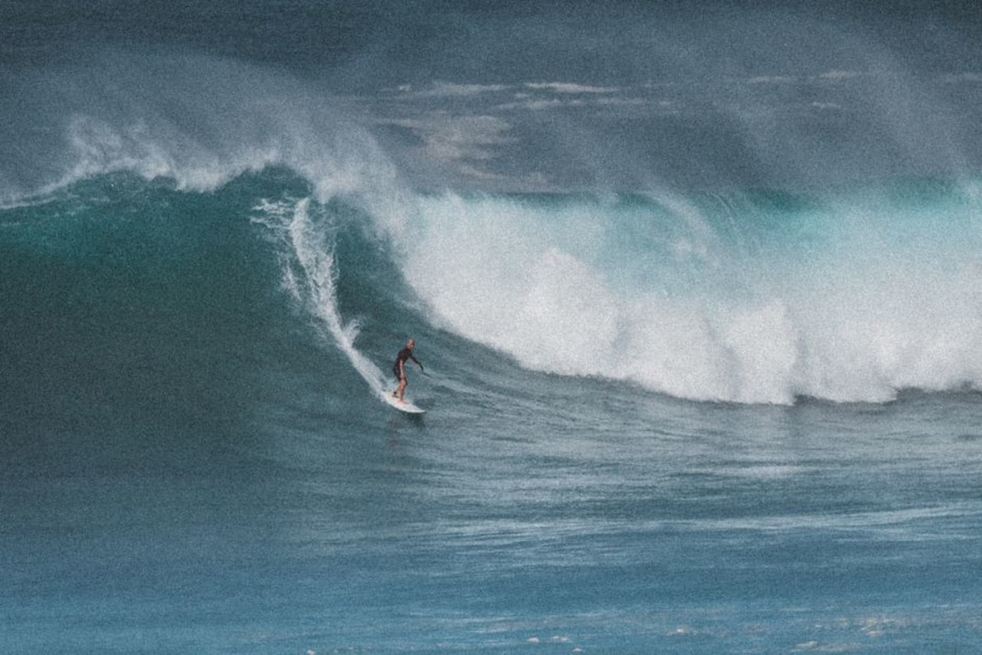The barreling right-hand wave at Lagundri Bay, Nias Island, with green hills behind