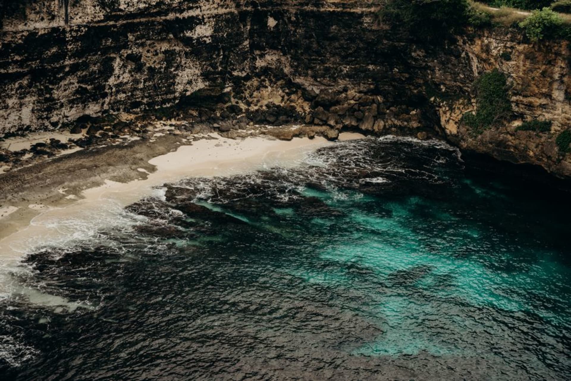 Turquoise water and limestone cliffs along the coastline of Nusa Lembongan