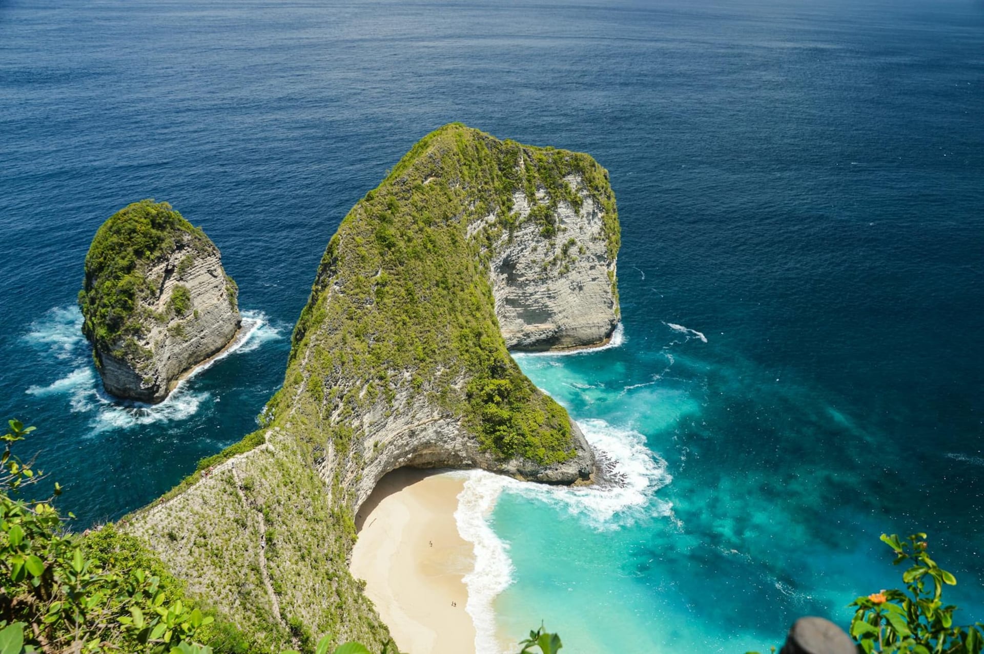 Kelingking Beach on Nusa Penida seen from above, the T-Rex shaped limestone headland jutting into turquoise water with a narrow strip of white sand below