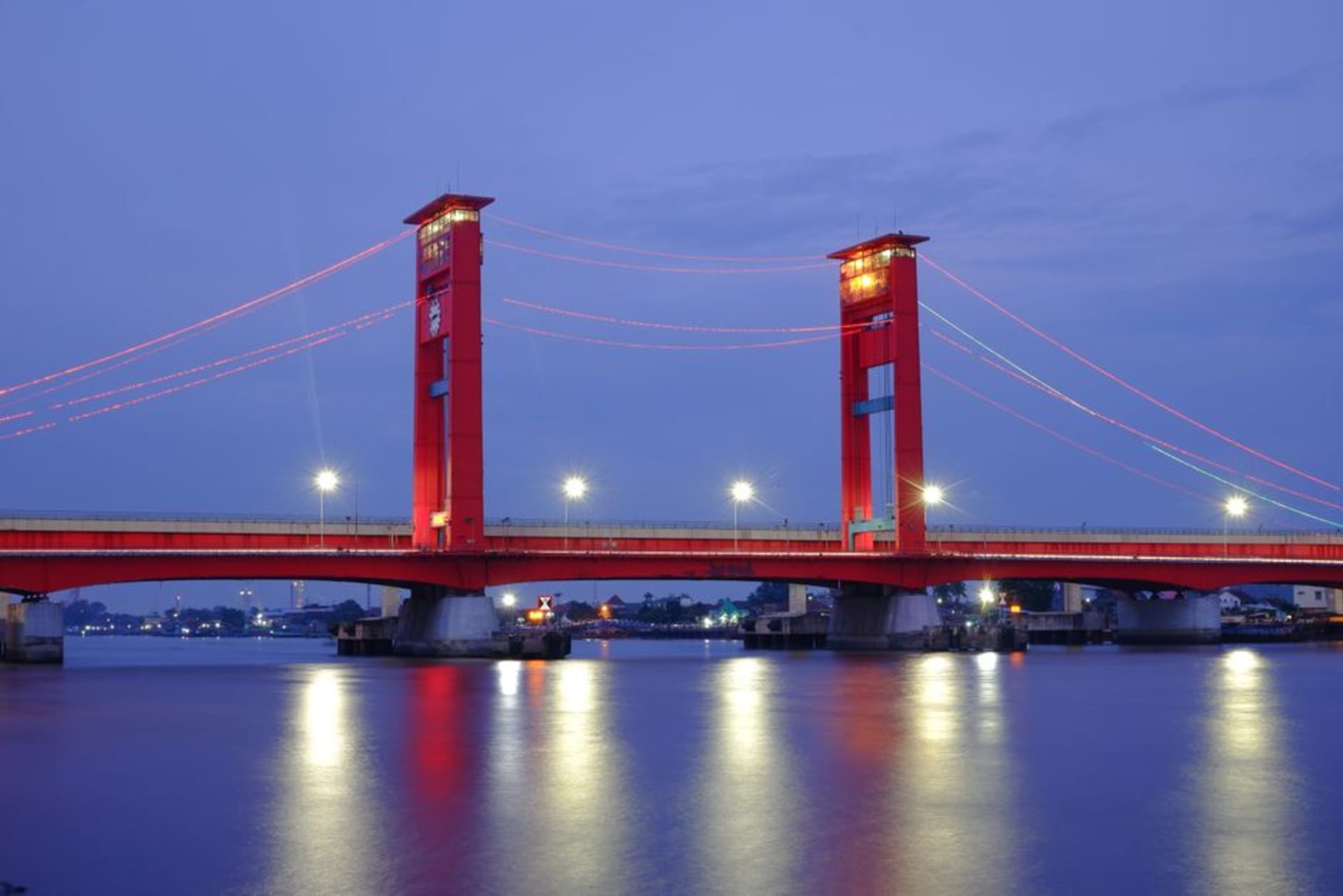The Ampera Bridge illuminated at dusk over the Musi River in Palembang