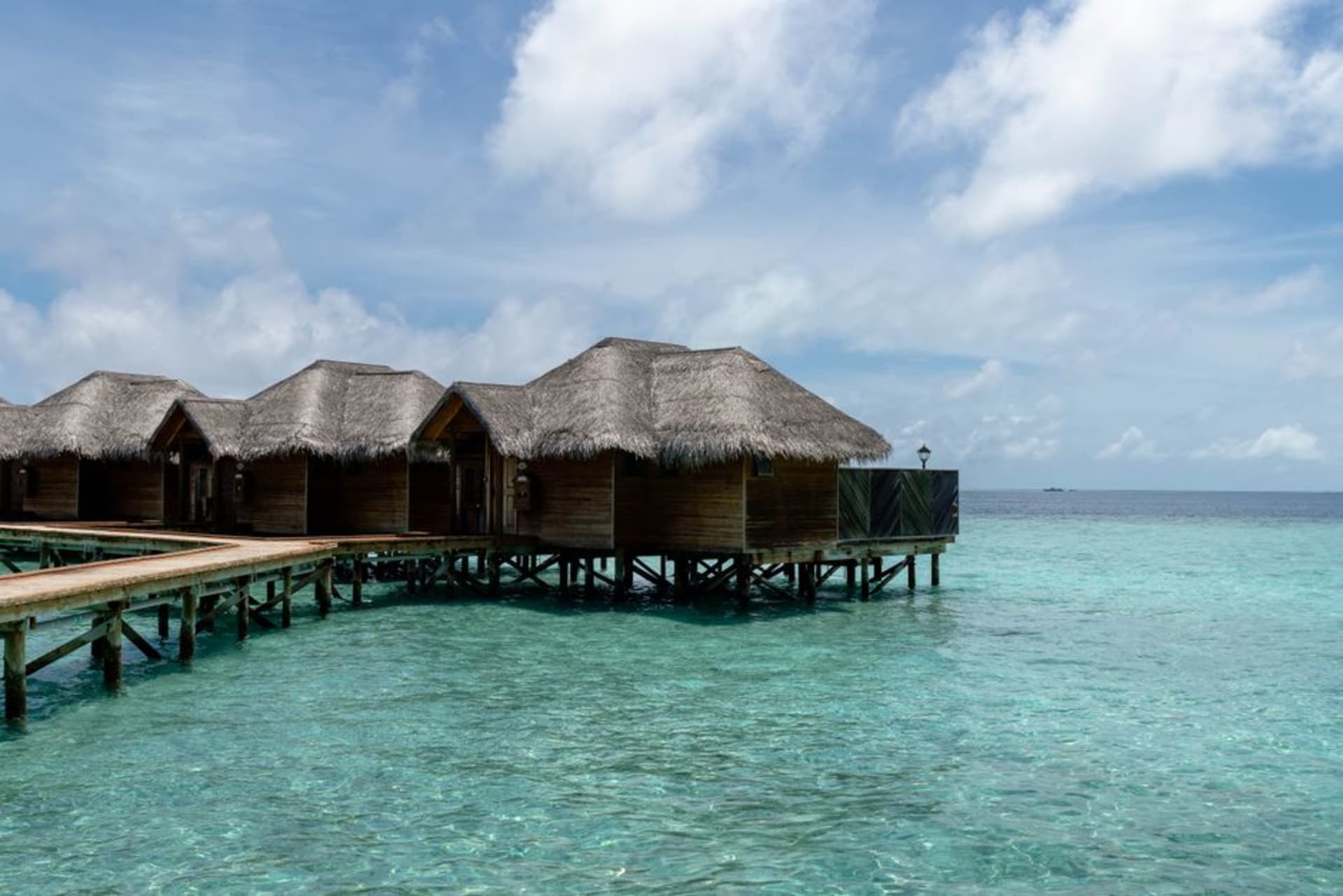 Overwater bungalow and jetty over clear turquoise water in the Togean Islands