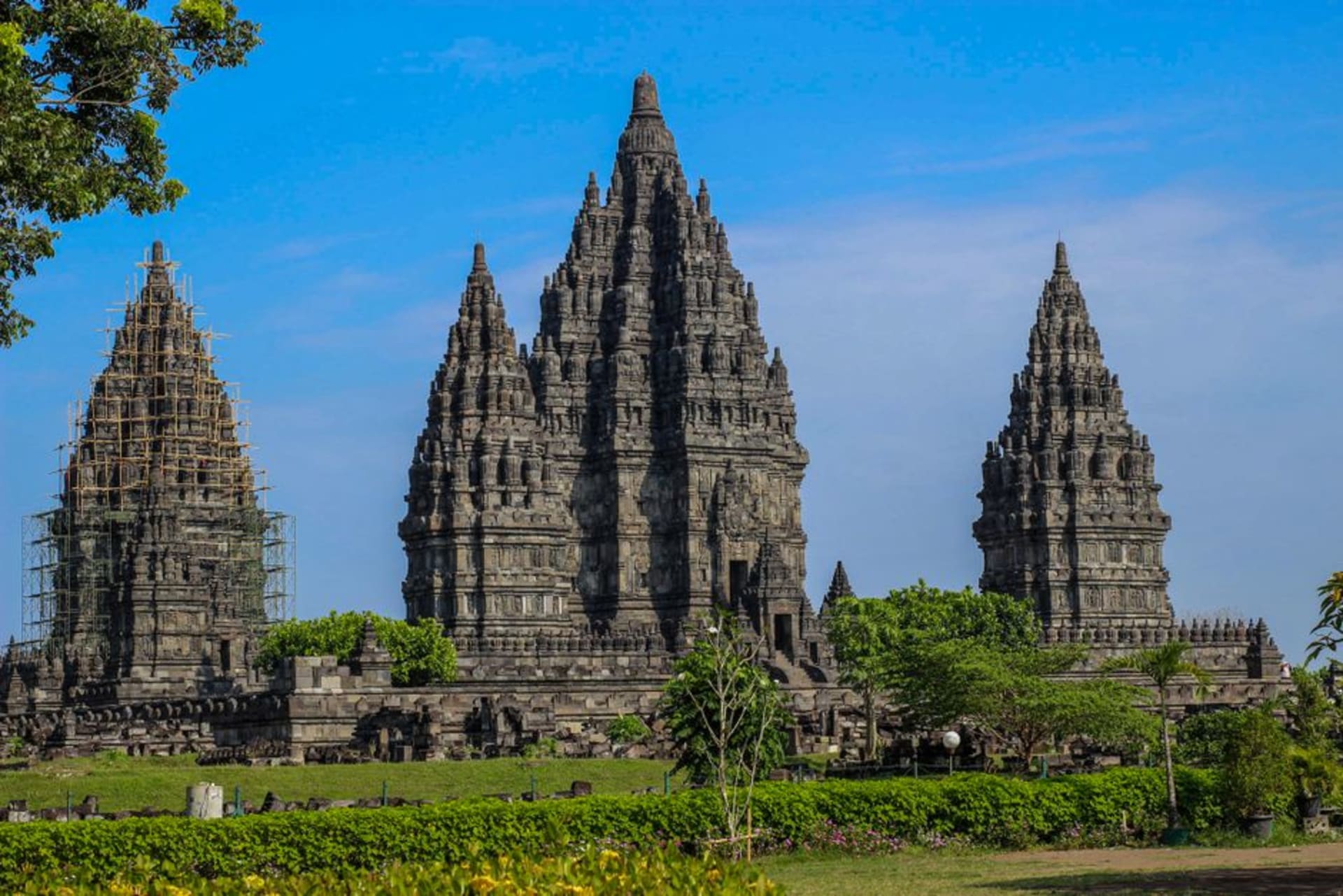 Towering stone spires of Prambanan temple complex against a blue sky in Central Java