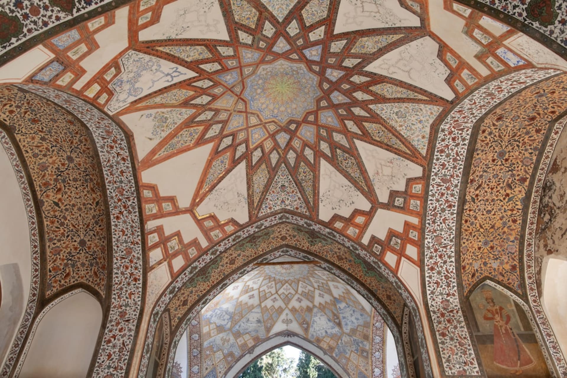 Un long canal-miroir carrelé de turquoise bordé de grands cyprès à l'intérieur du jardin de Fin à Kashan, menant vers un pavillon