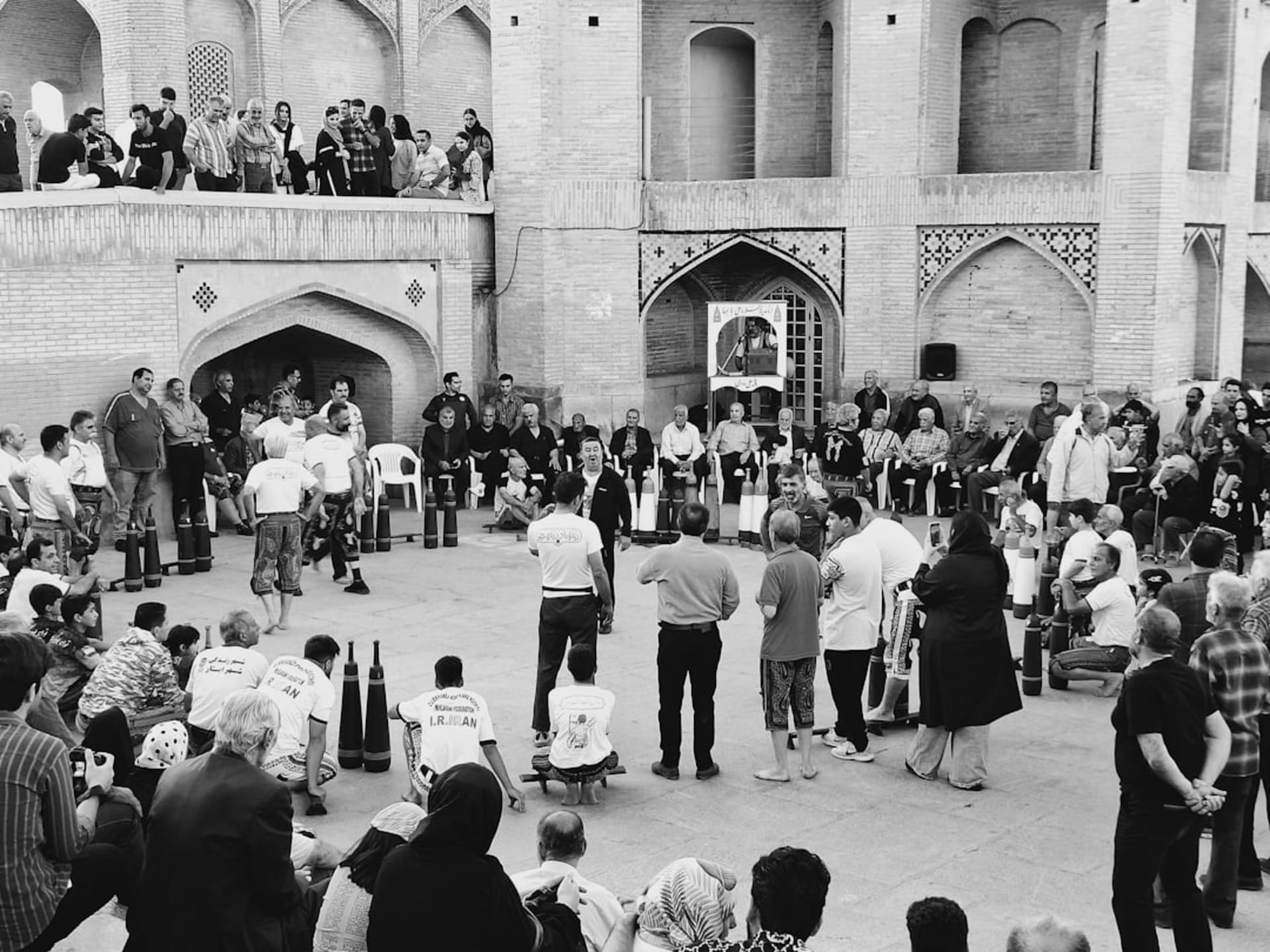 The brick courtyard of the Jameh Mosque of Isfahan with its iwan and minarets under a pale morning sky