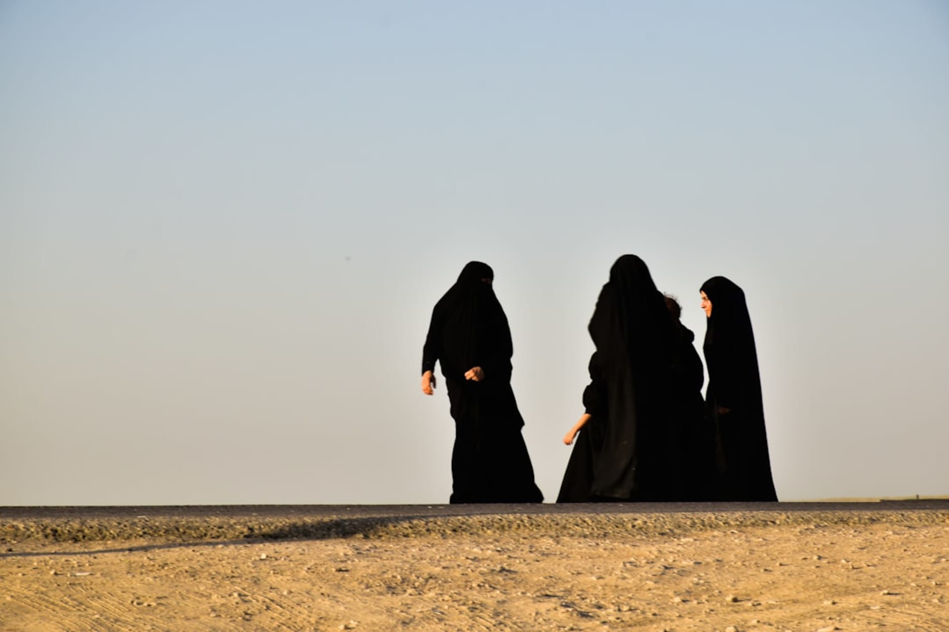 Dunes de sable doré ondulées du désert de Rig-e Yazd sous un ciel de coucher de soleil chaud avec de longues ombres