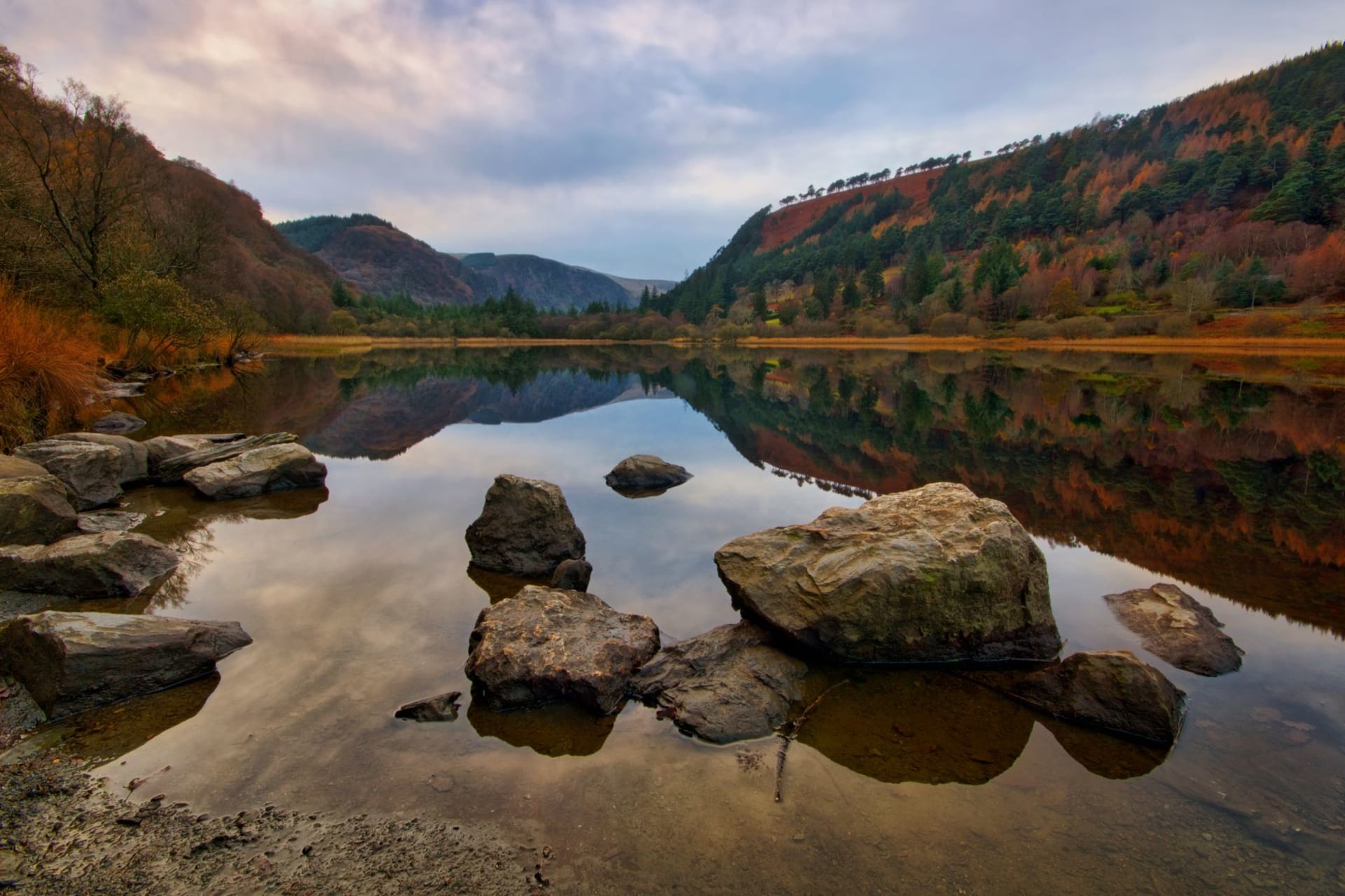 The round tower and monastic ruins of Glendalough among trees in the Wicklow Mountains