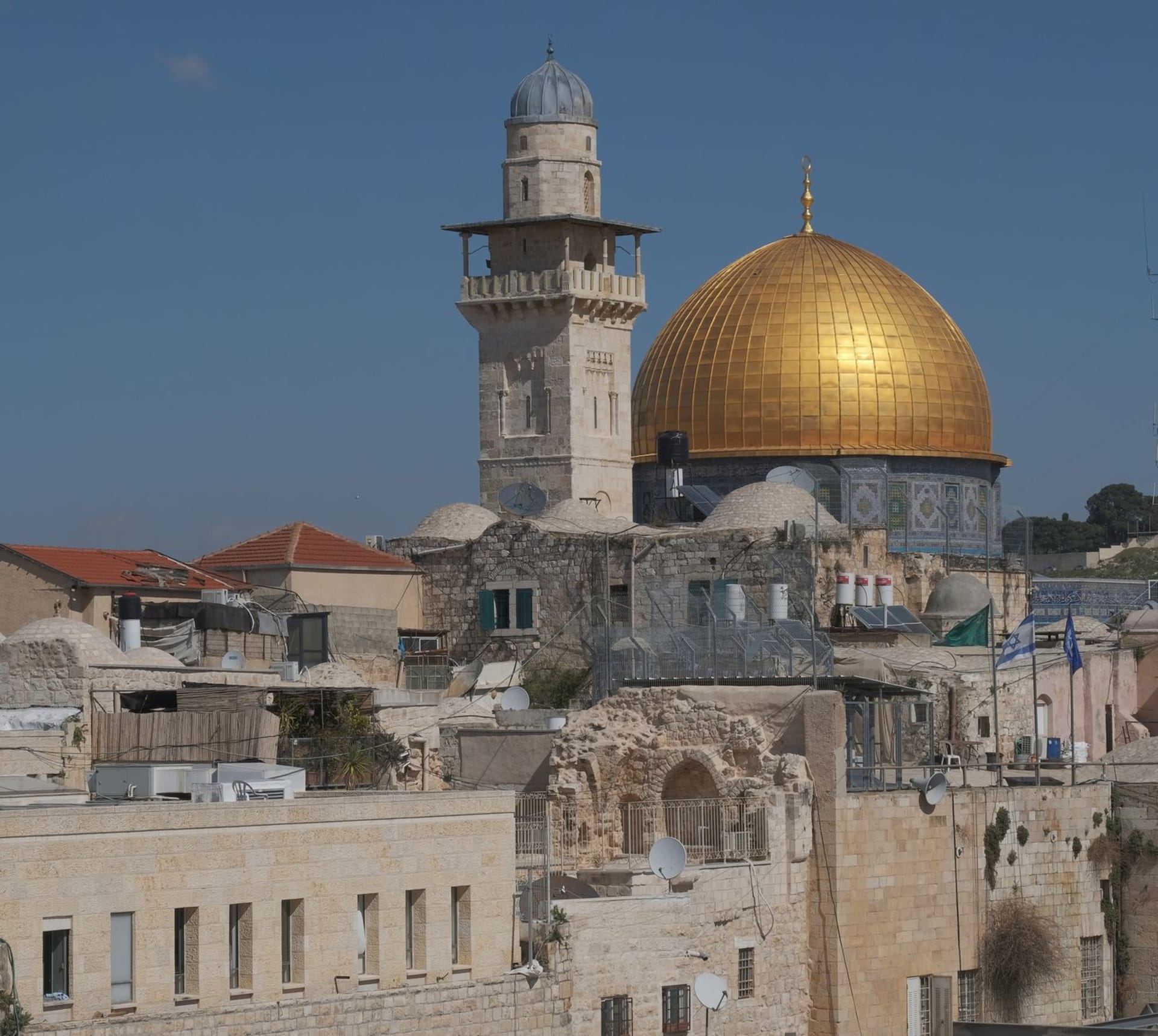 Le Dôme du Rocher doré se dressant au-dessus des toits superposés et des minarets de la vieille ville de Jérusalem.