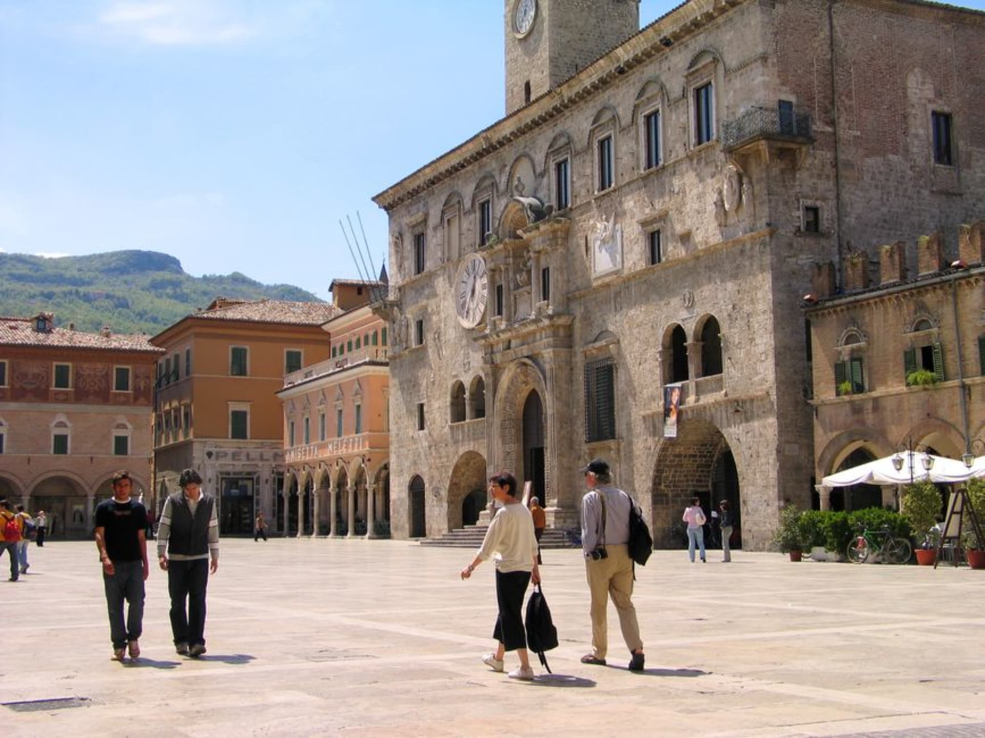 The travertine facades of Piazza del Popolo in Ascoli Piceno glowing at golden hour