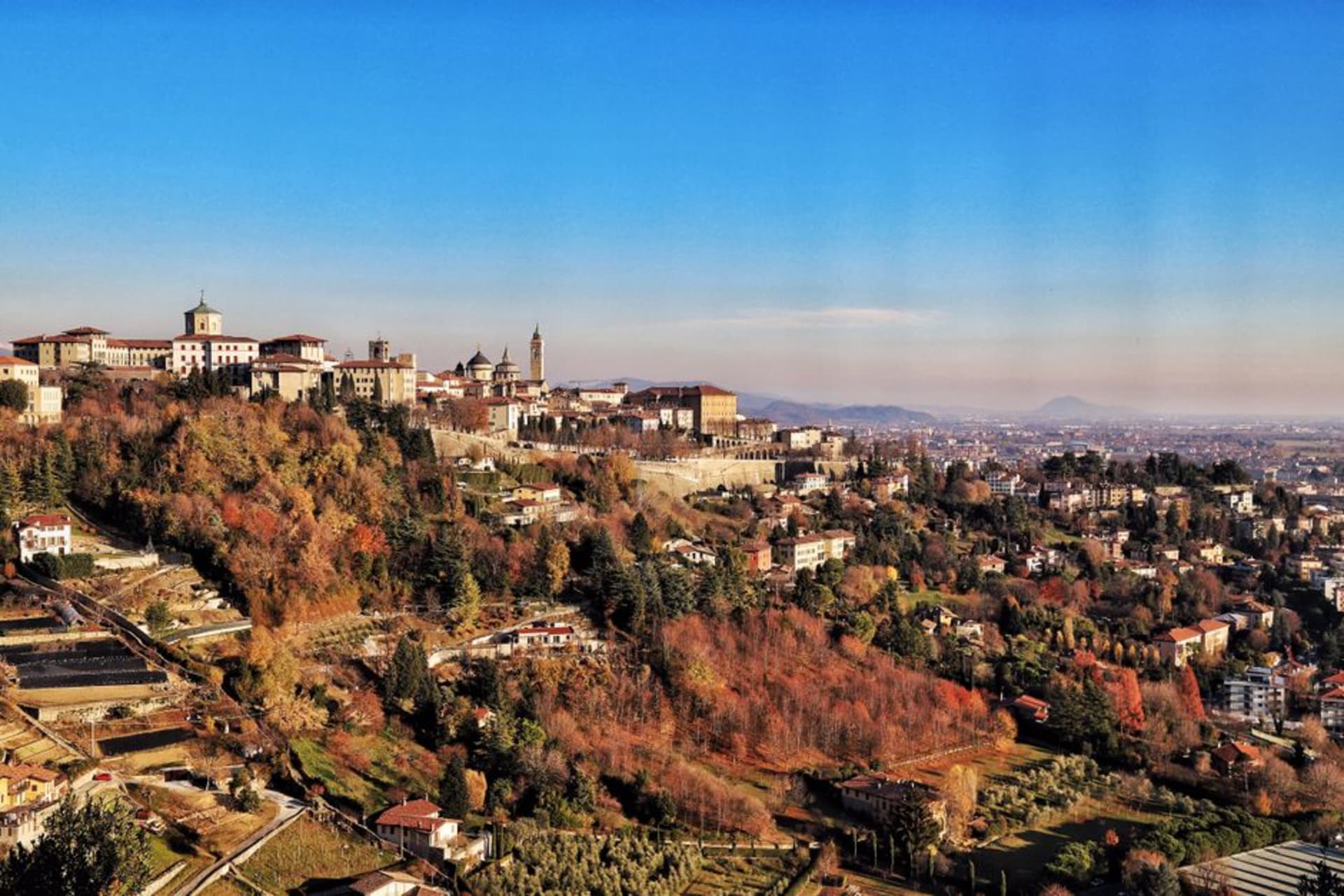 The walled hilltop city of Bergamo Alta rising above the Lombard plain at sunset