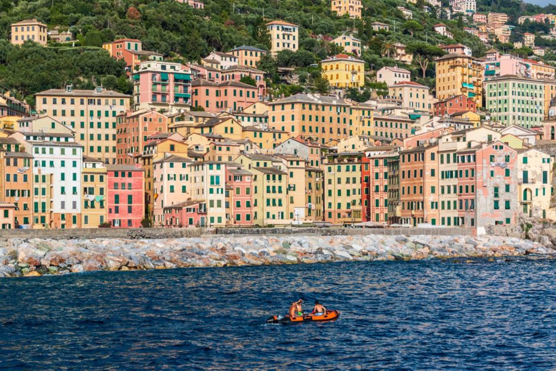 Tall pastel houses with painted trompe-l'oeil facades lining the harbor of Camogli