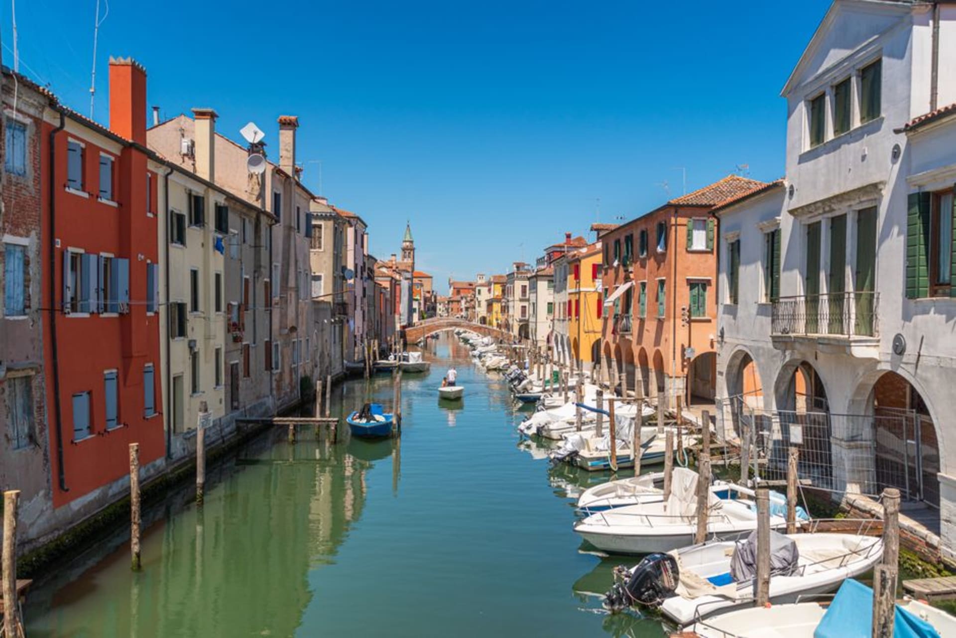 Colorful fishing boats moored along the Vena canal in Chioggia