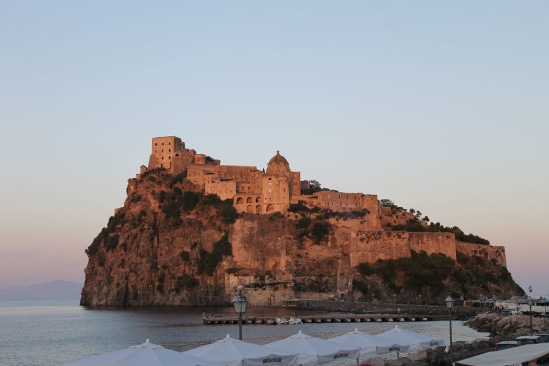 The Aragonese Castle of Ischia connected to the main island by a stone bridge, seen at golden hour