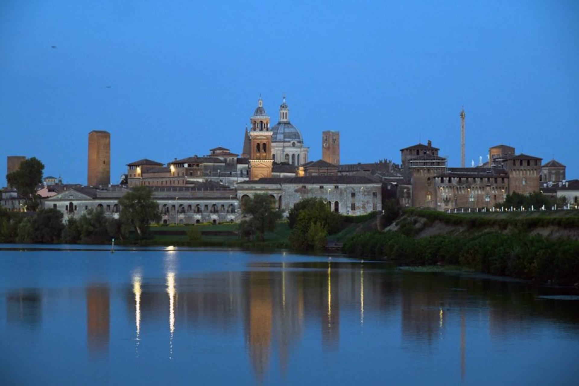 Mantua's skyline reflected in the still waters of Lake di Mezzo at dusk