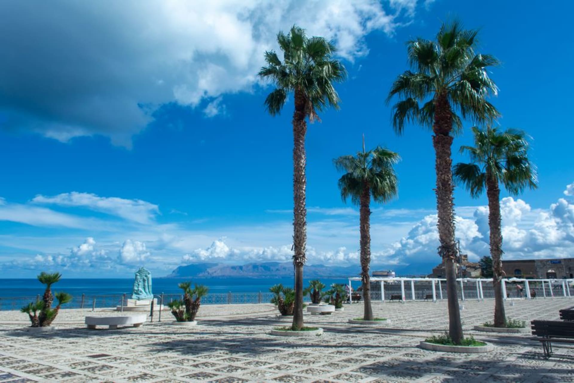 Reggio Calabria's palm-lined seafront promenade with Sicily visible across the Strait of Messina