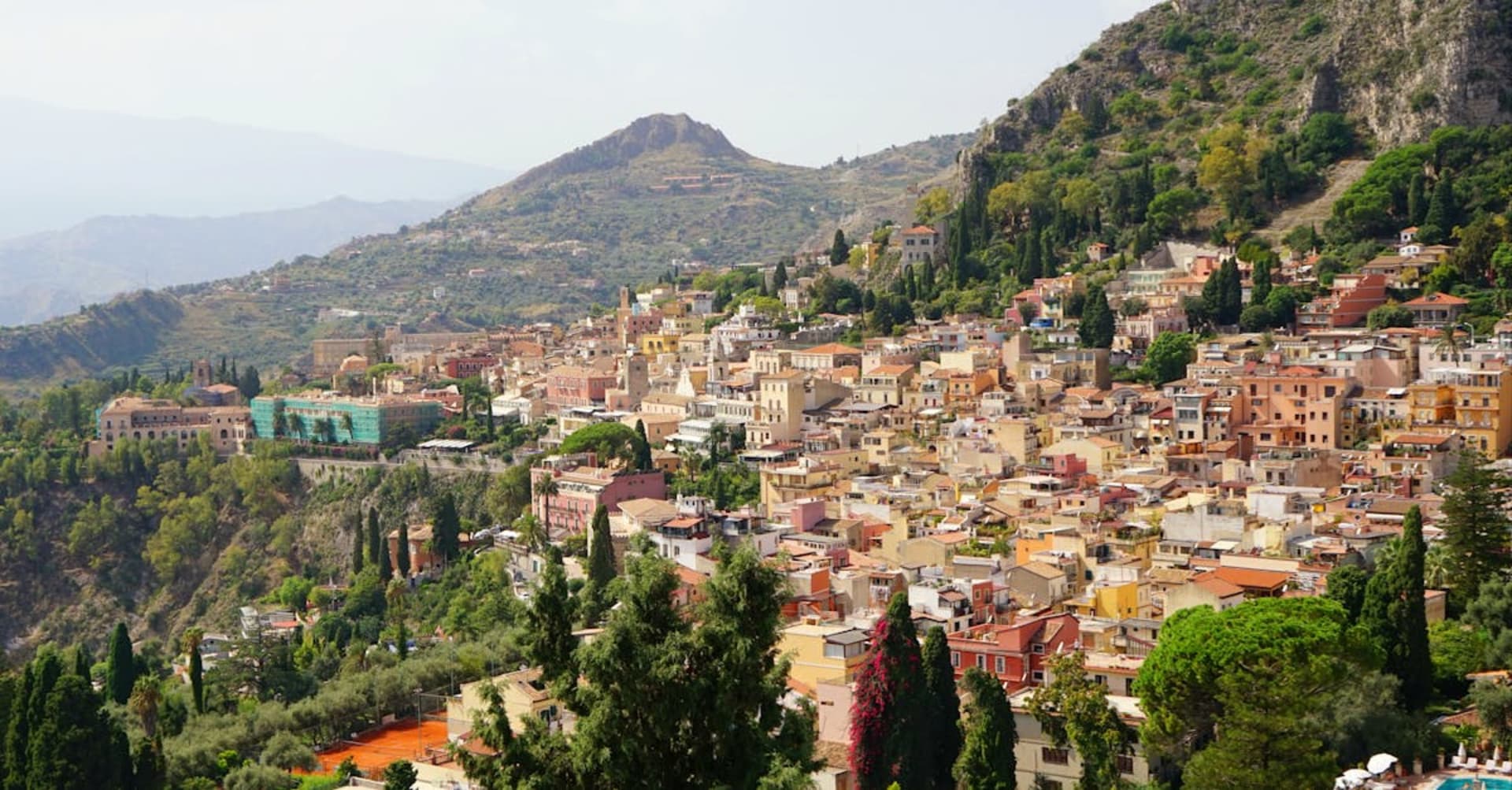 Mount Etna smoking gently above vineyards and terracotta rooftops in Sicily
