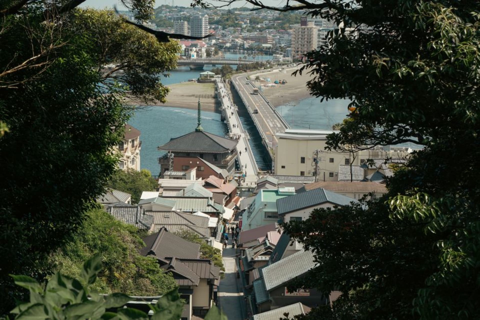 The green hump of Enoshima island rising from the sea off the Shōnan coast, connected to the mainland by a long low bridge