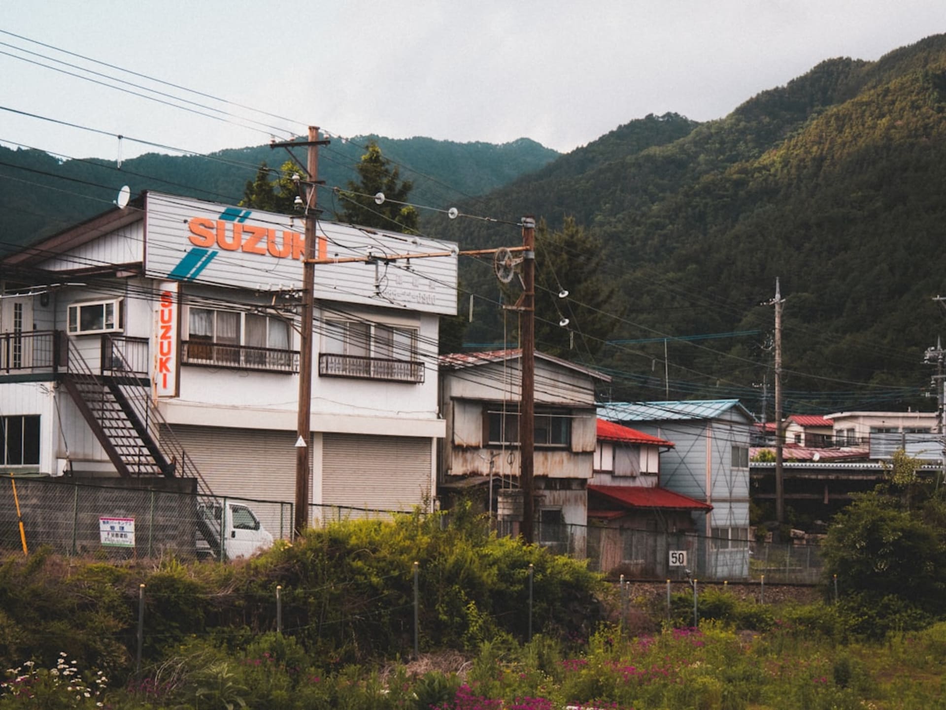 The Hida river running through Gero Onsen with ryokan terraced up the wooded mountainside, steam rising in the cool air