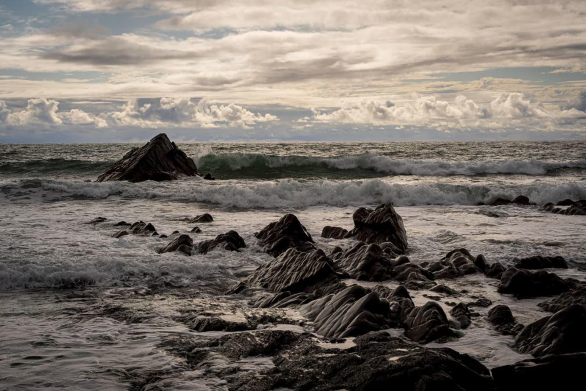 Rocky Sea of Japan coastline at Itoigawa with steep green mountains behind