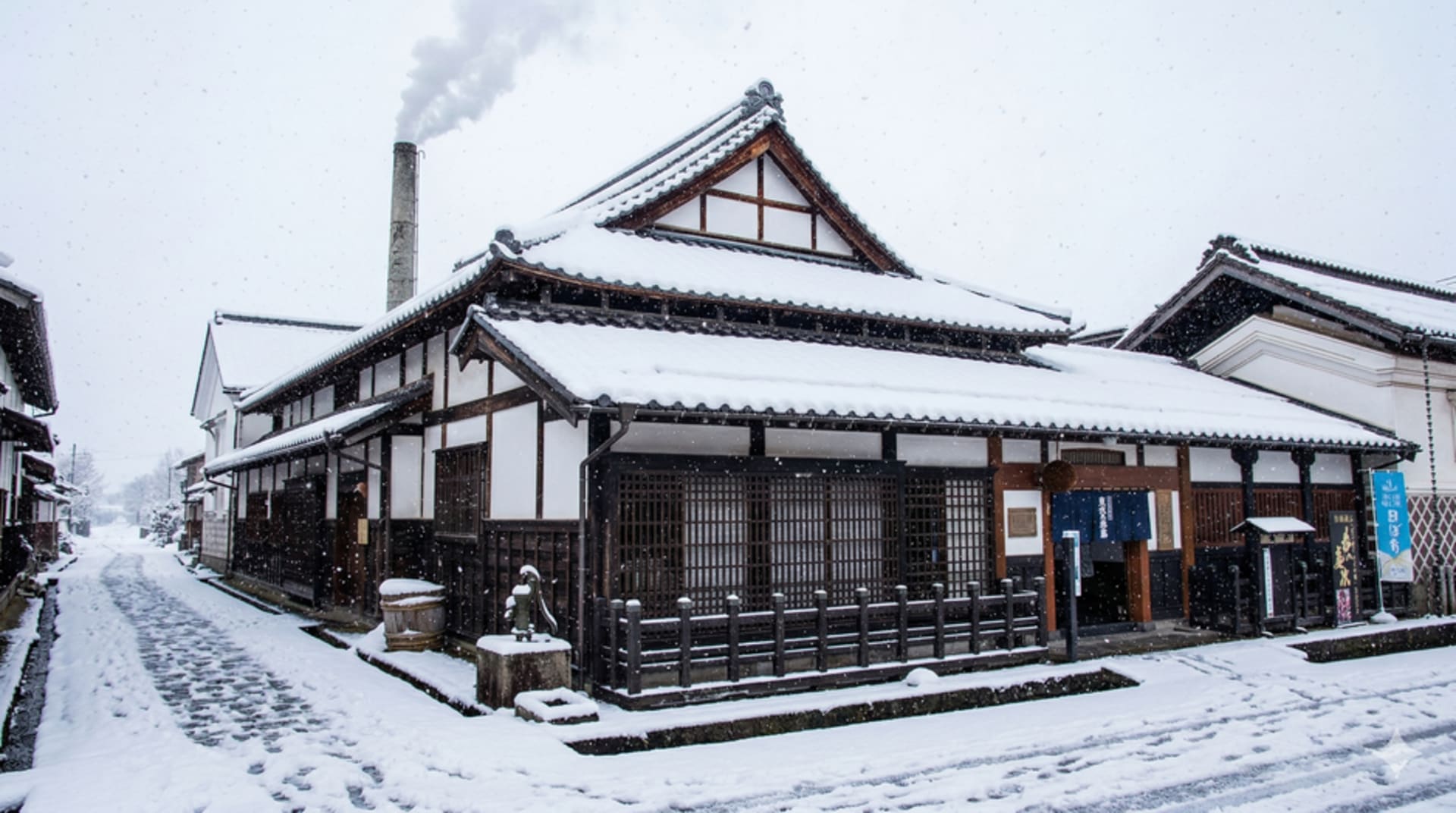 Row of black-walled Edo-era kura storehouses lining a quiet street in Kitakata, Fukushima