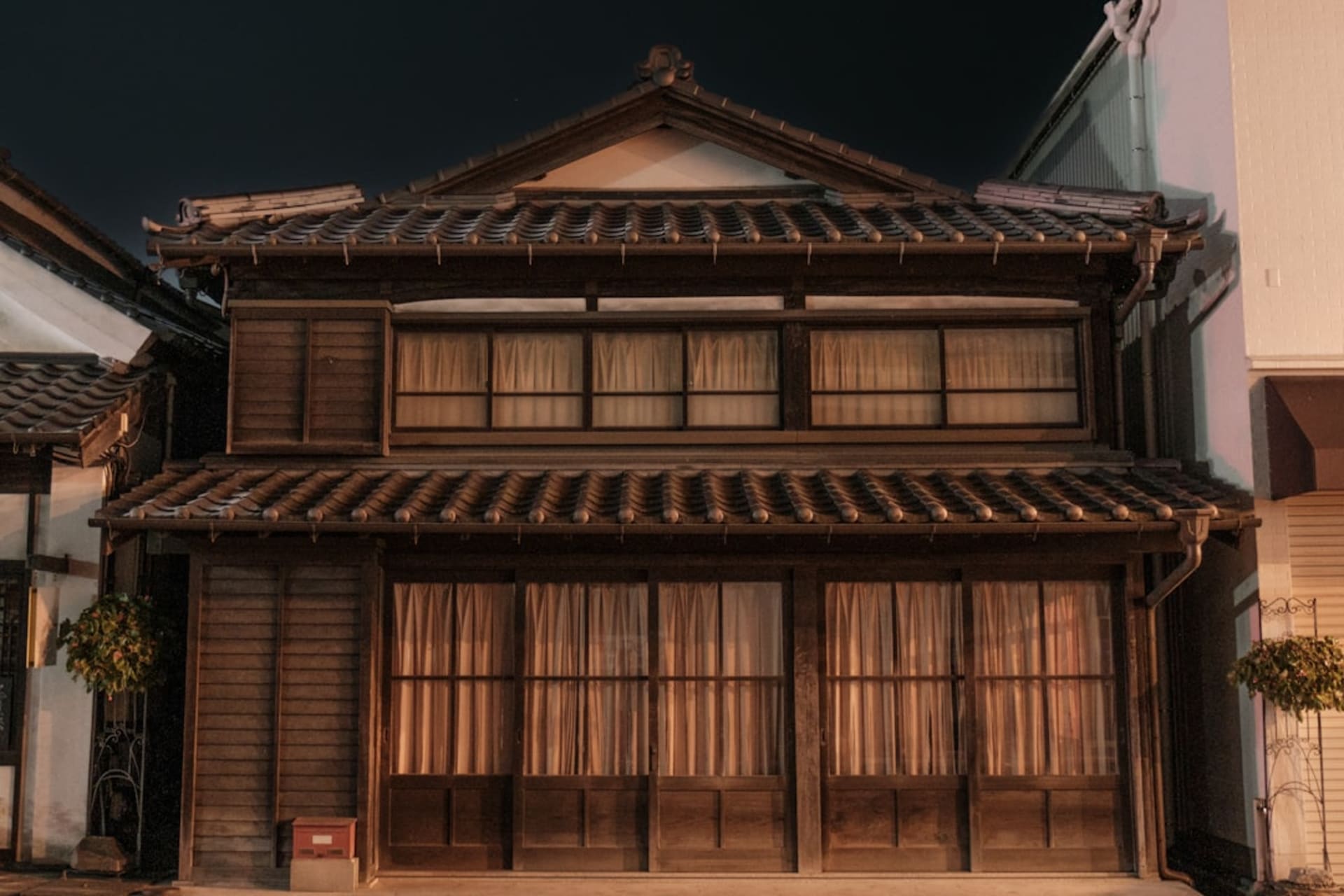 The long main street of Narai lined with two-story wooden houses with dark latticed facades and deep overhanging eaves under a grey Kiso sky
