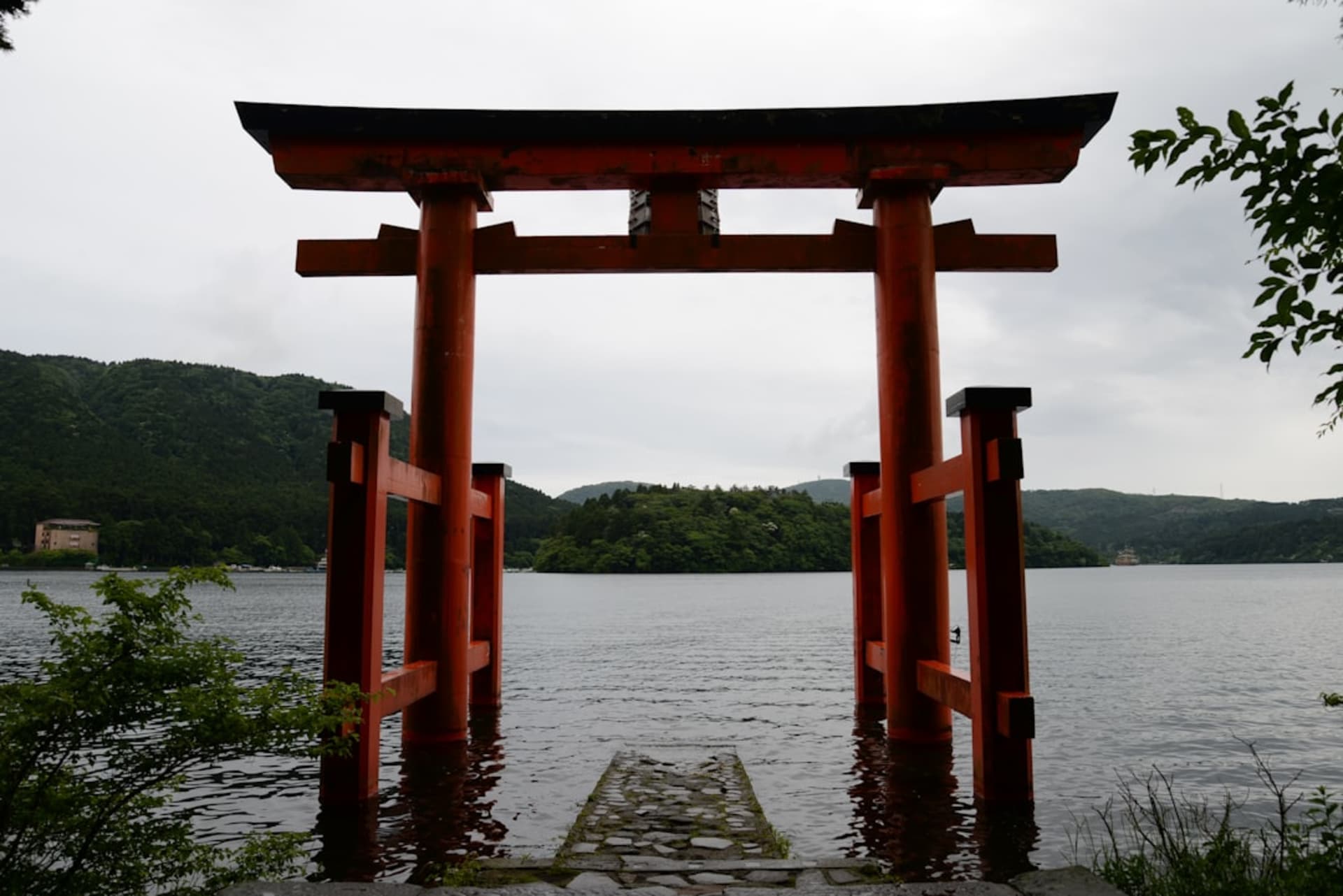 Lake Suwa at dawn ringed by mountains with mist rising off the water in Nagano