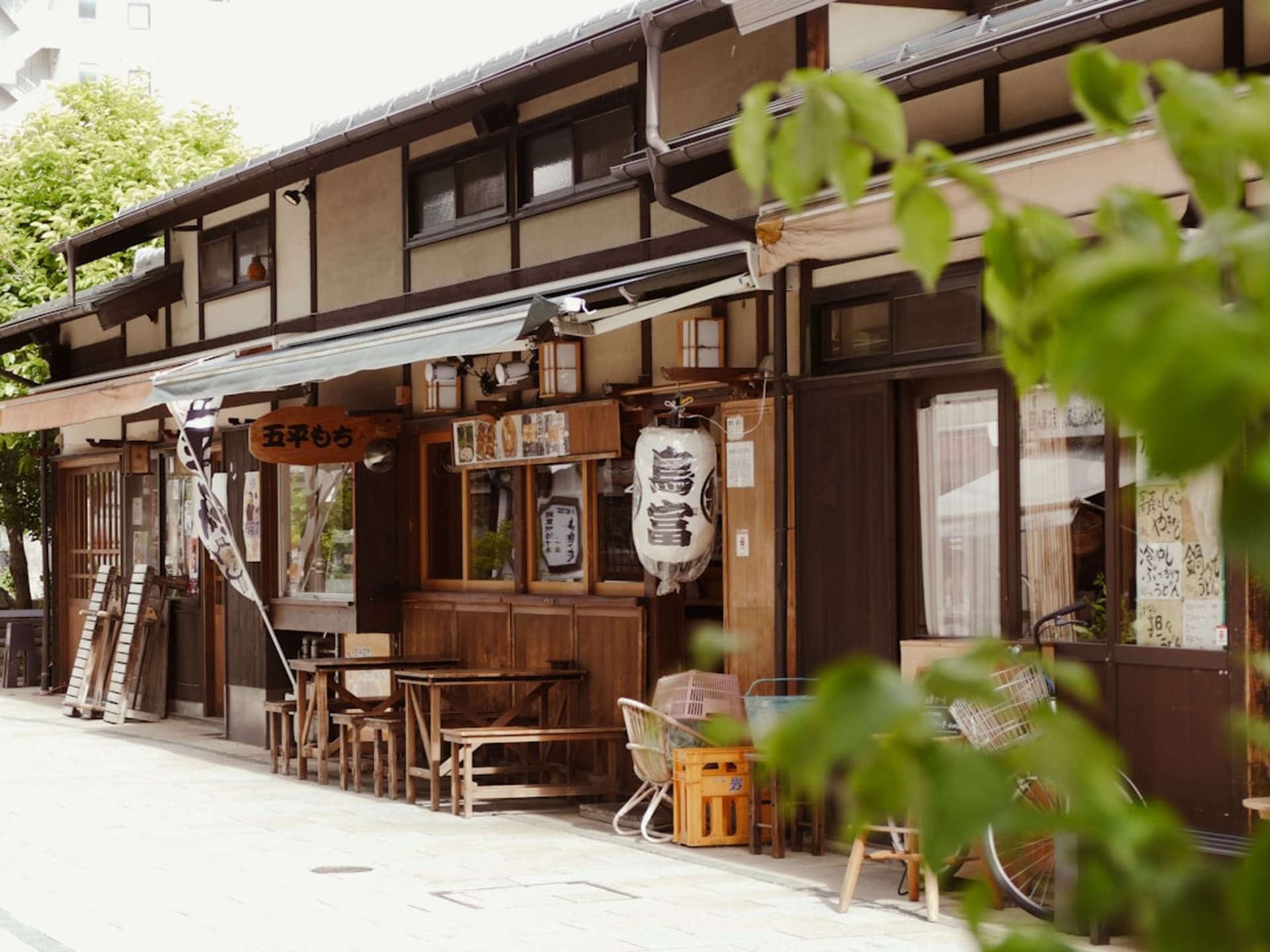 Dark wooden merchant houses lining the Sanmachi district of Takayama under a soft mountain sky