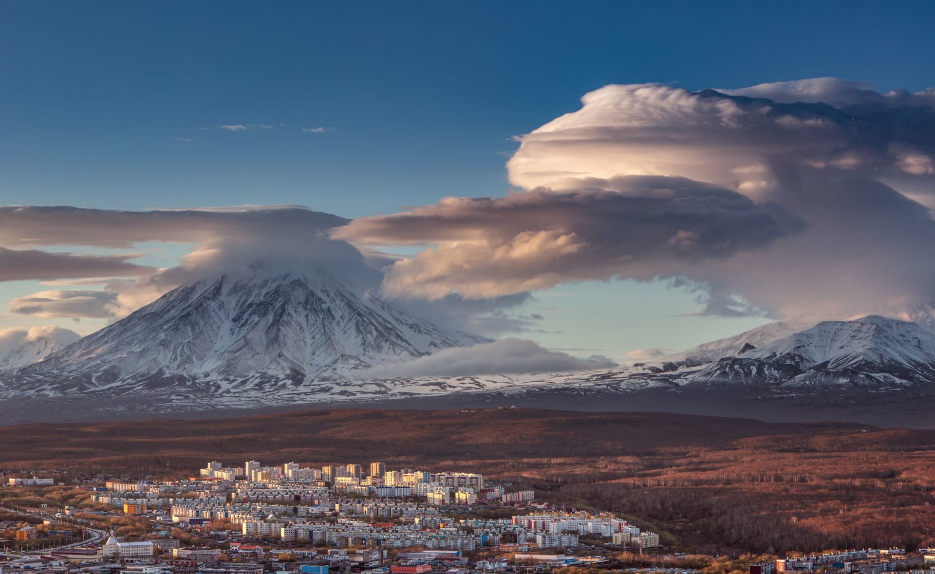Petropavlovsk-Kamchatsky harbour with the volcanic peaks of Avacha and Koryaksky rising behind the city in morning light