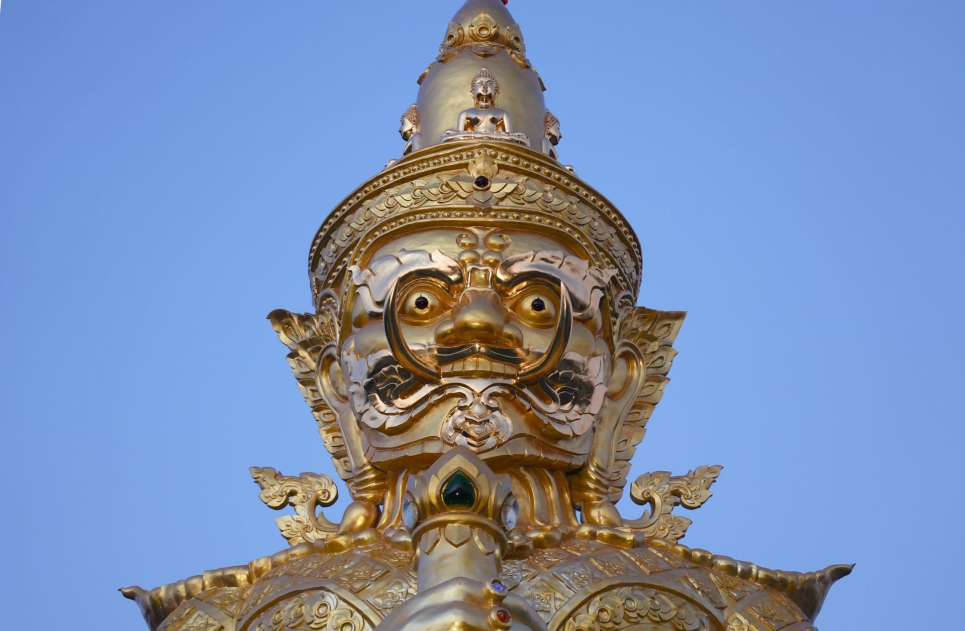 The golden Big Buddha statue at Wat Phra Yai rising above the blue sea on its small island, connected to Samui by a causeway