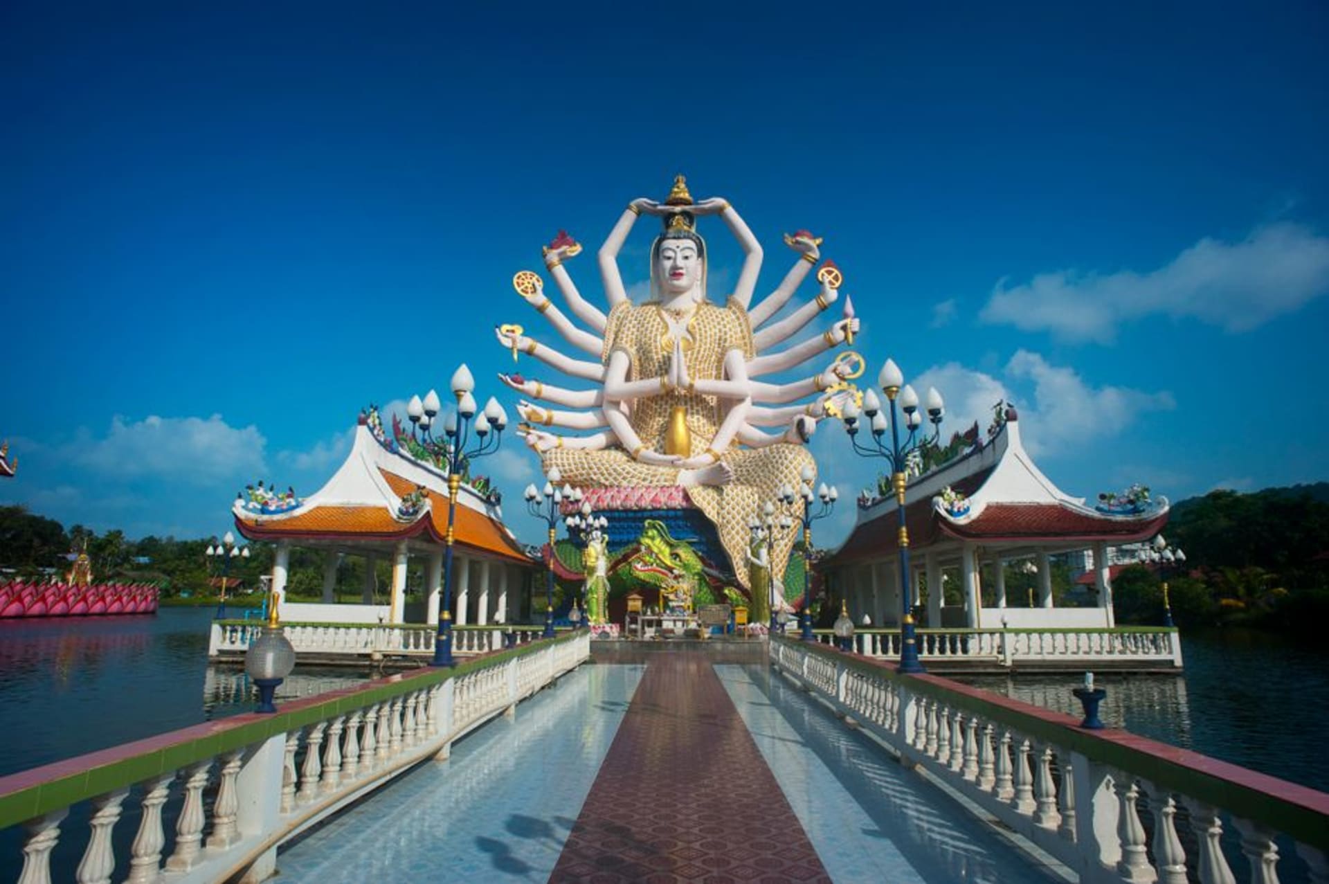 La estatua de Guanyin de 18 brazos sentada sobre una plataforma de loto en el lago de Wat Plai Laem