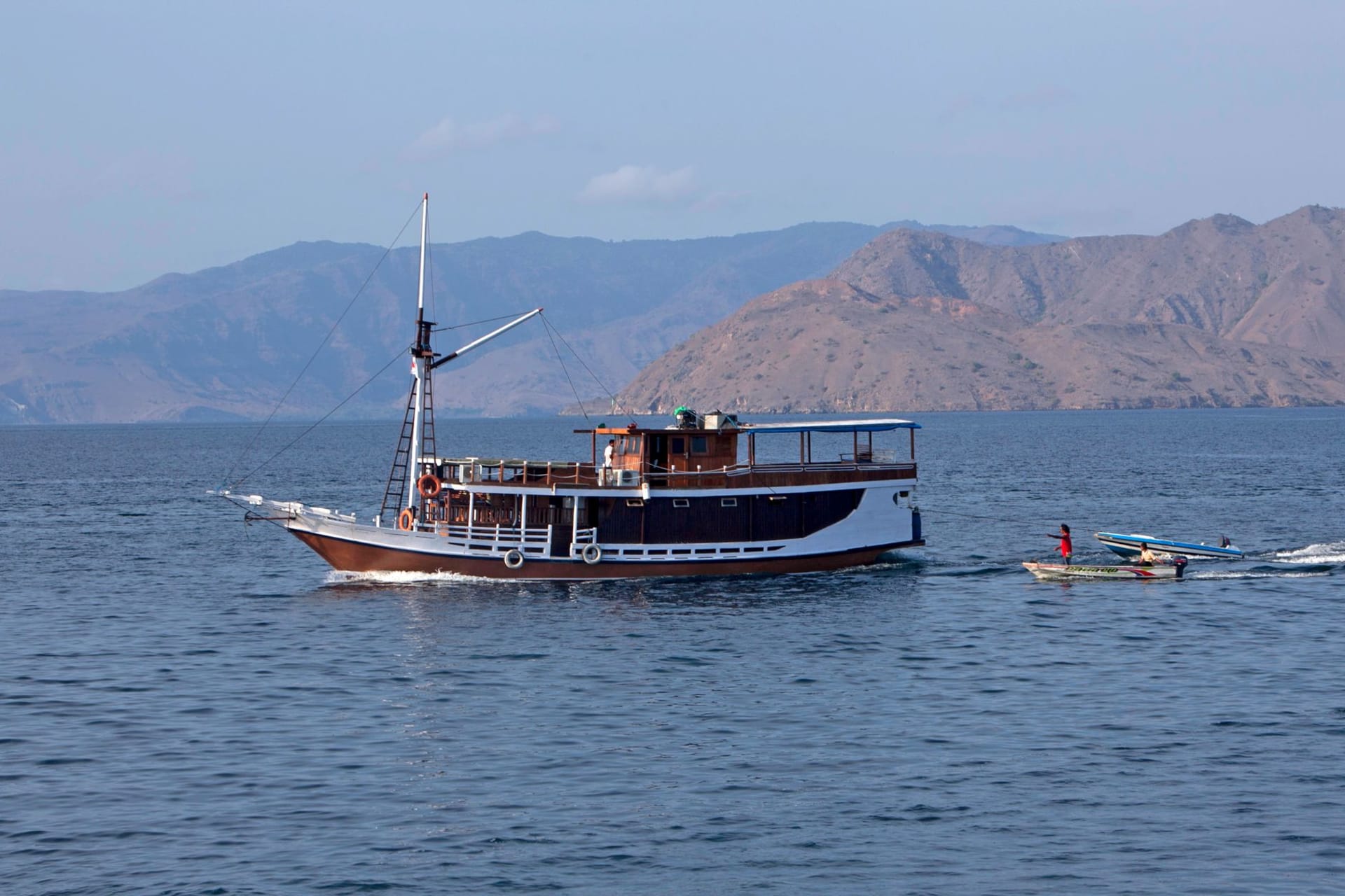 The curving pink-white sandbar of Taka Makassar emerging from turquoise shallows in Komodo National Park, with no vegetation and surrounded by reef