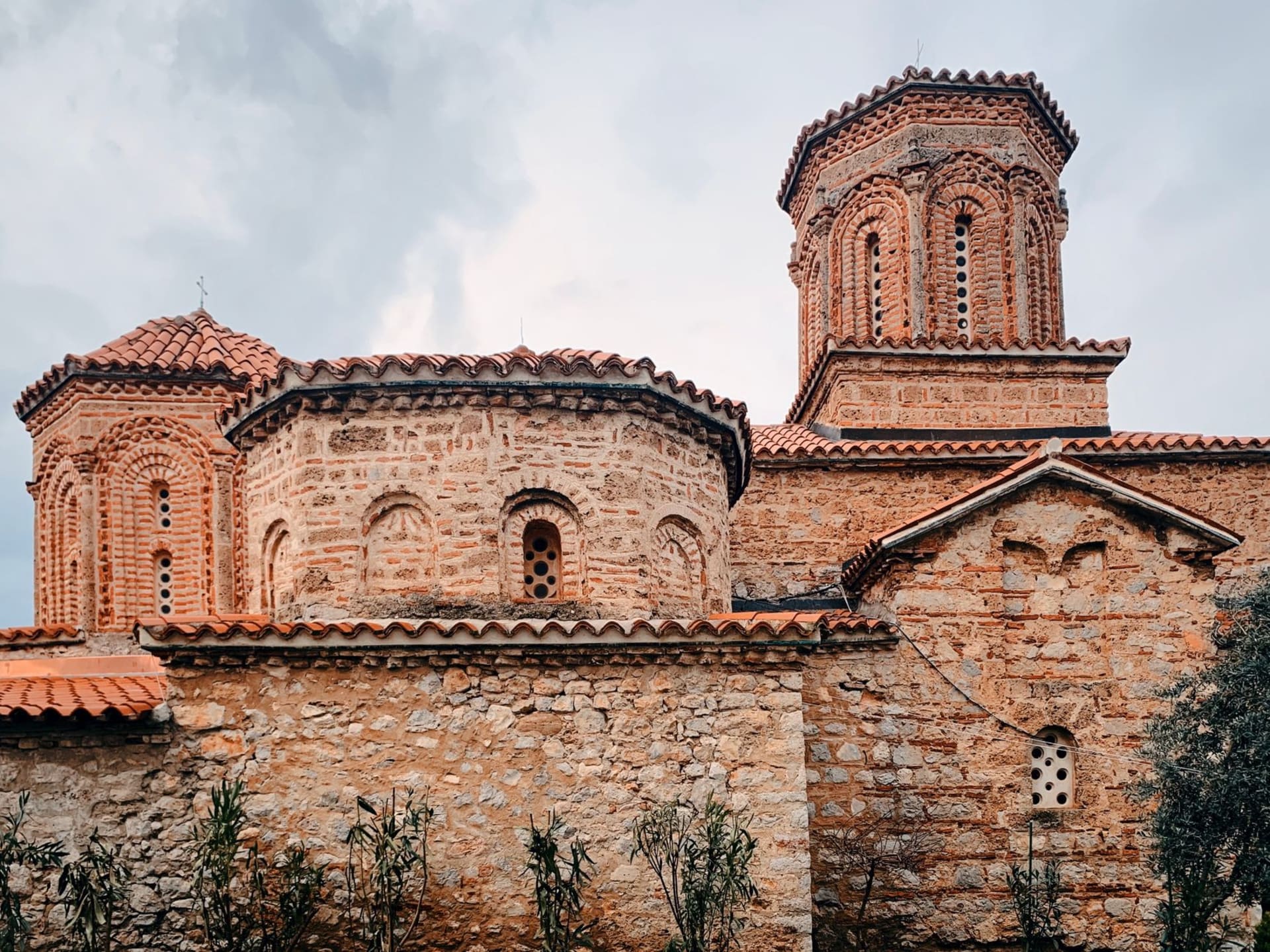 L'église romano-byzantine du monastère Visoki Dečani se dressant d'une vallée boisée au Kosovo, brume matinale dans les arbres