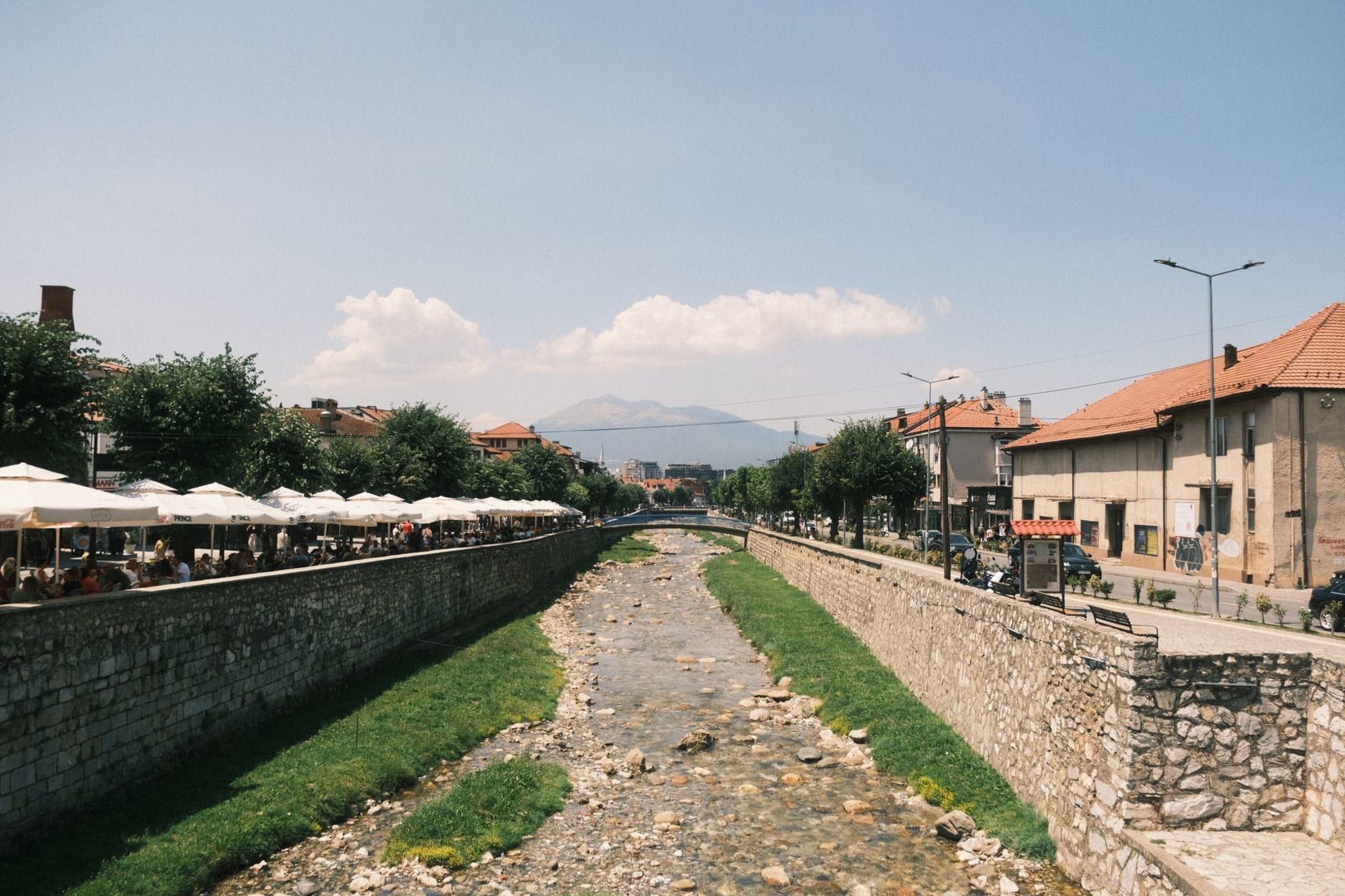 Le pont principal sur la rivière Ibar à Mitrovica avec la ville divisée s'élevant sur les deux rives sous un ciel hivernal