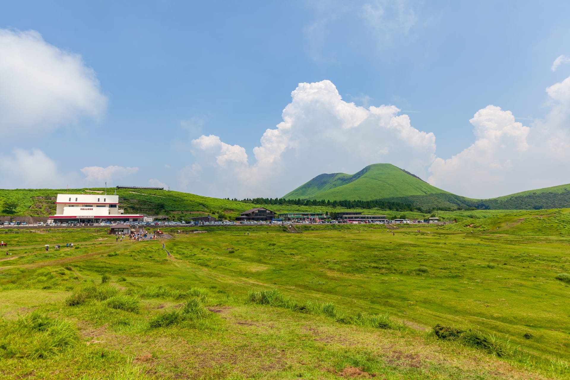 Rolling green volcanic hills of Mount Aso caldera under a wide blue sky, Kyushu, Japan