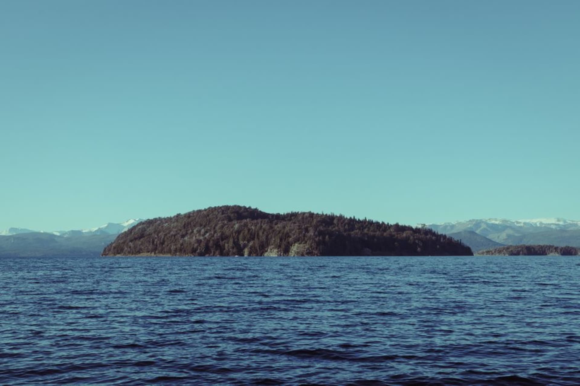 The barge crossing to Isla Huapi with the green hills of the island rising from Lago Ranco