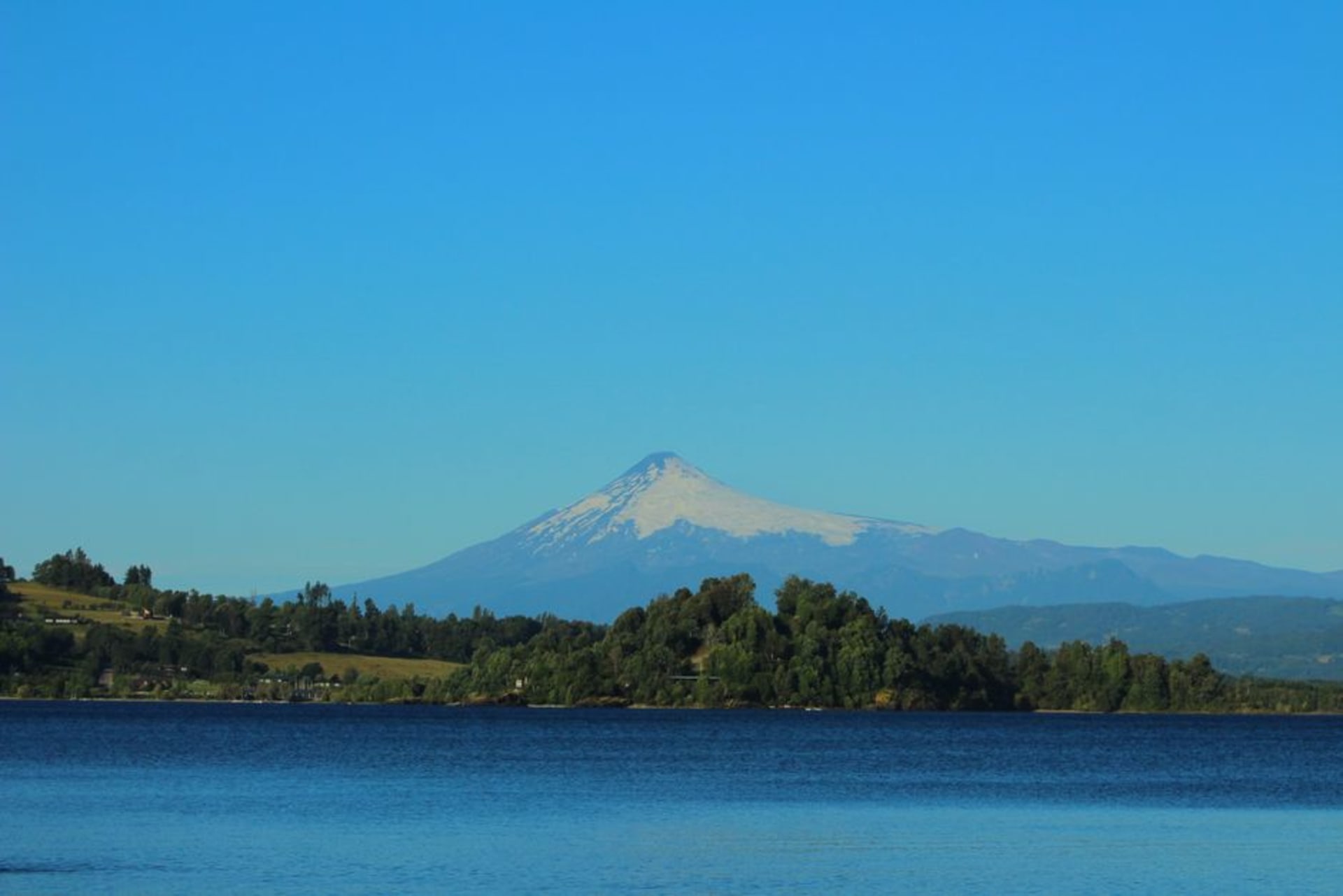 The rose-lined waterfront promenade of Panguipulli with the lake and forested hills behind