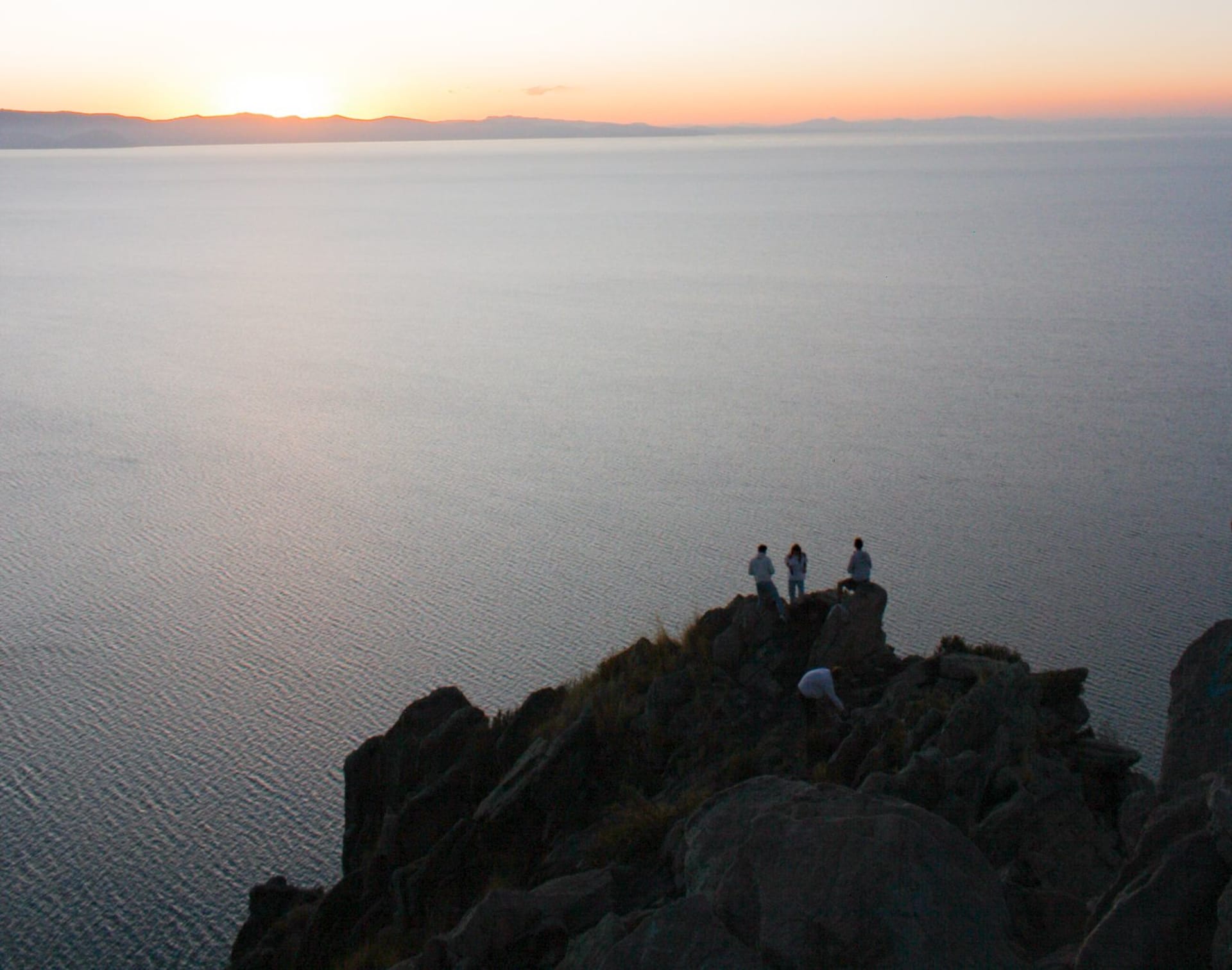 The quiet reed-fringed shores of Anapia Island in Lake Titicaca's southern Wiñaymarca basin with the snow-capped Cordillera Real reflected in still water