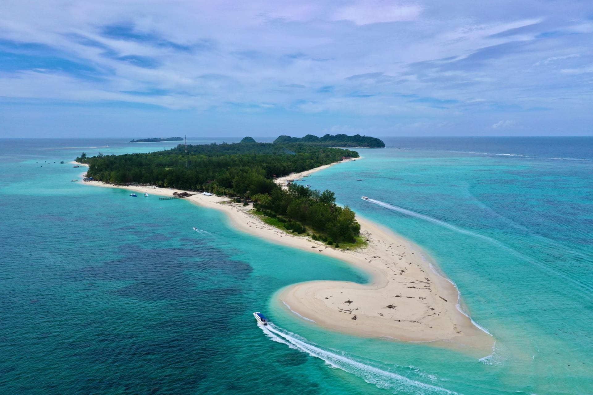 The clear turquoise shallows off Pulau Payar Marine Park, a forested island and a snorkelling platform on calm water, Malaysia